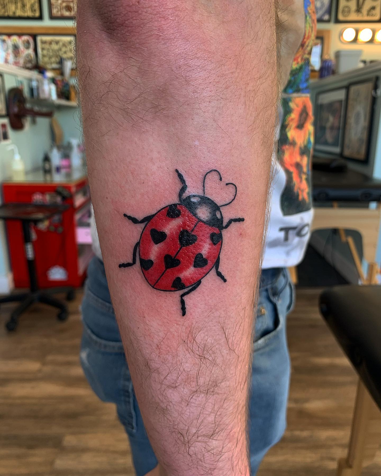 Ladybug trash polka tattoo on the forearm by Brii Moser