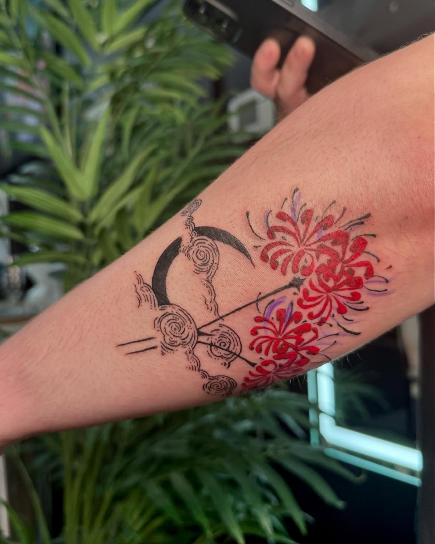 Moon and chrysanthemums watercolor tattoo on the forearm by Nina Rush