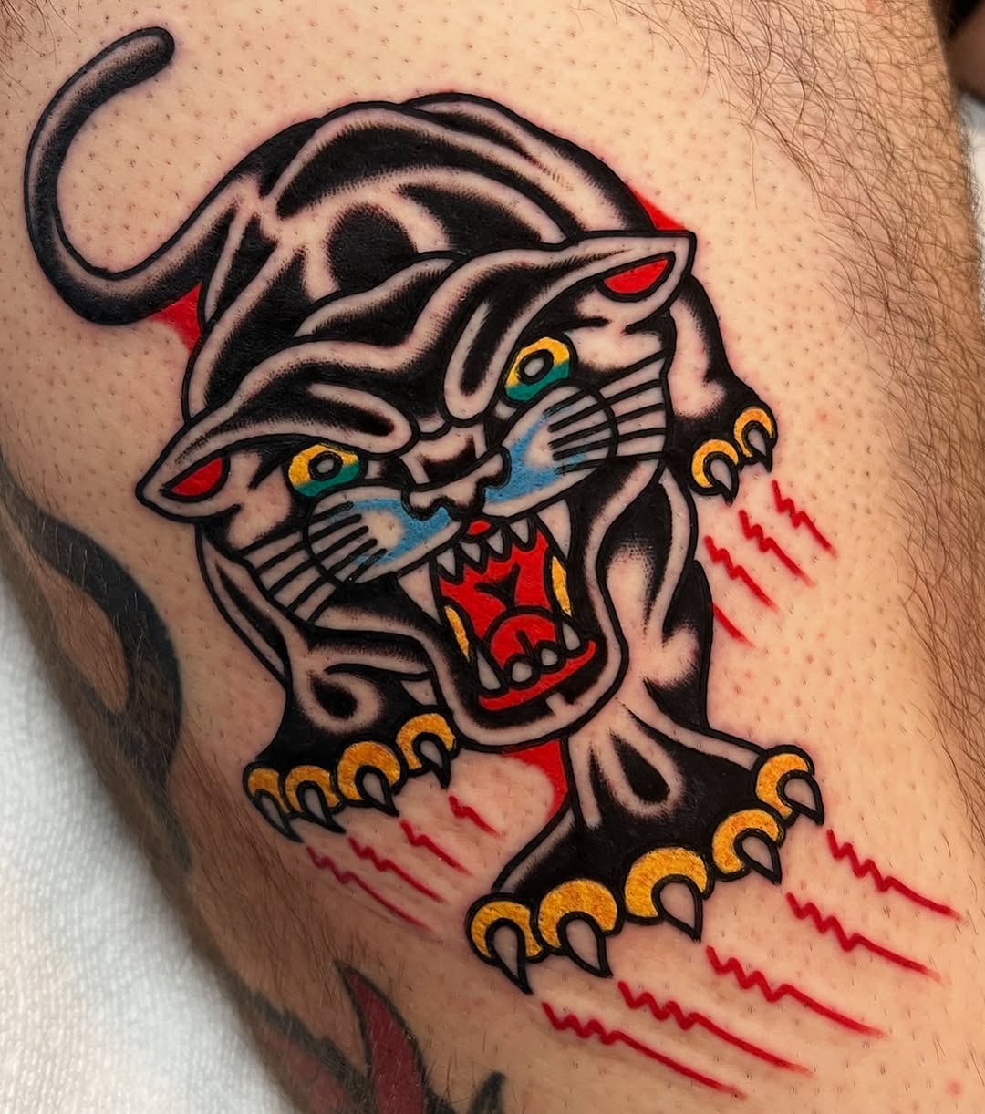 Panther realism tattoo on the upper arm by Ian Jett