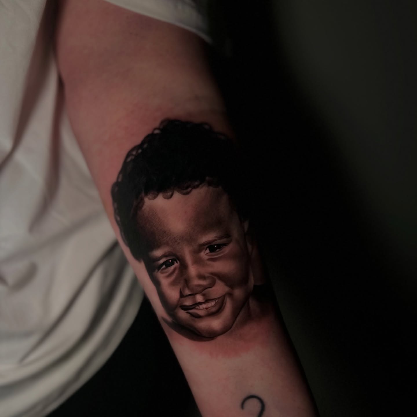 Child's face realism tattoo on the forearm by Vondrae