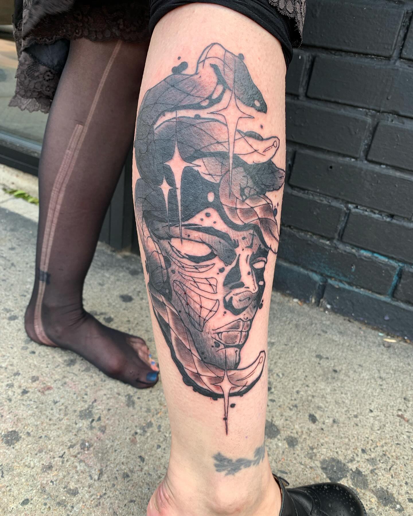 Abstract face geometric tattoo on the forearm by Ghost Ham Tattoos
