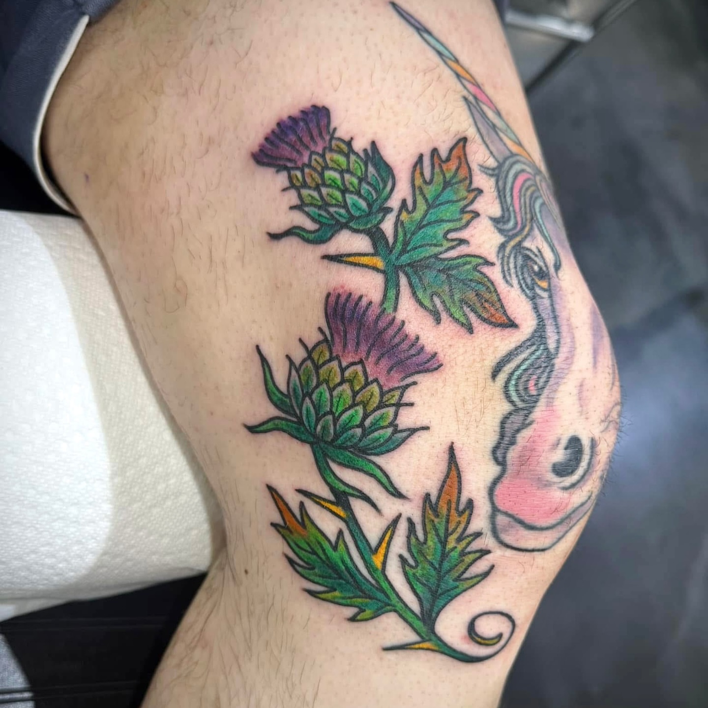 Thistle and unicorn American traditional tattoo on the thigh by Hayden Abernathy