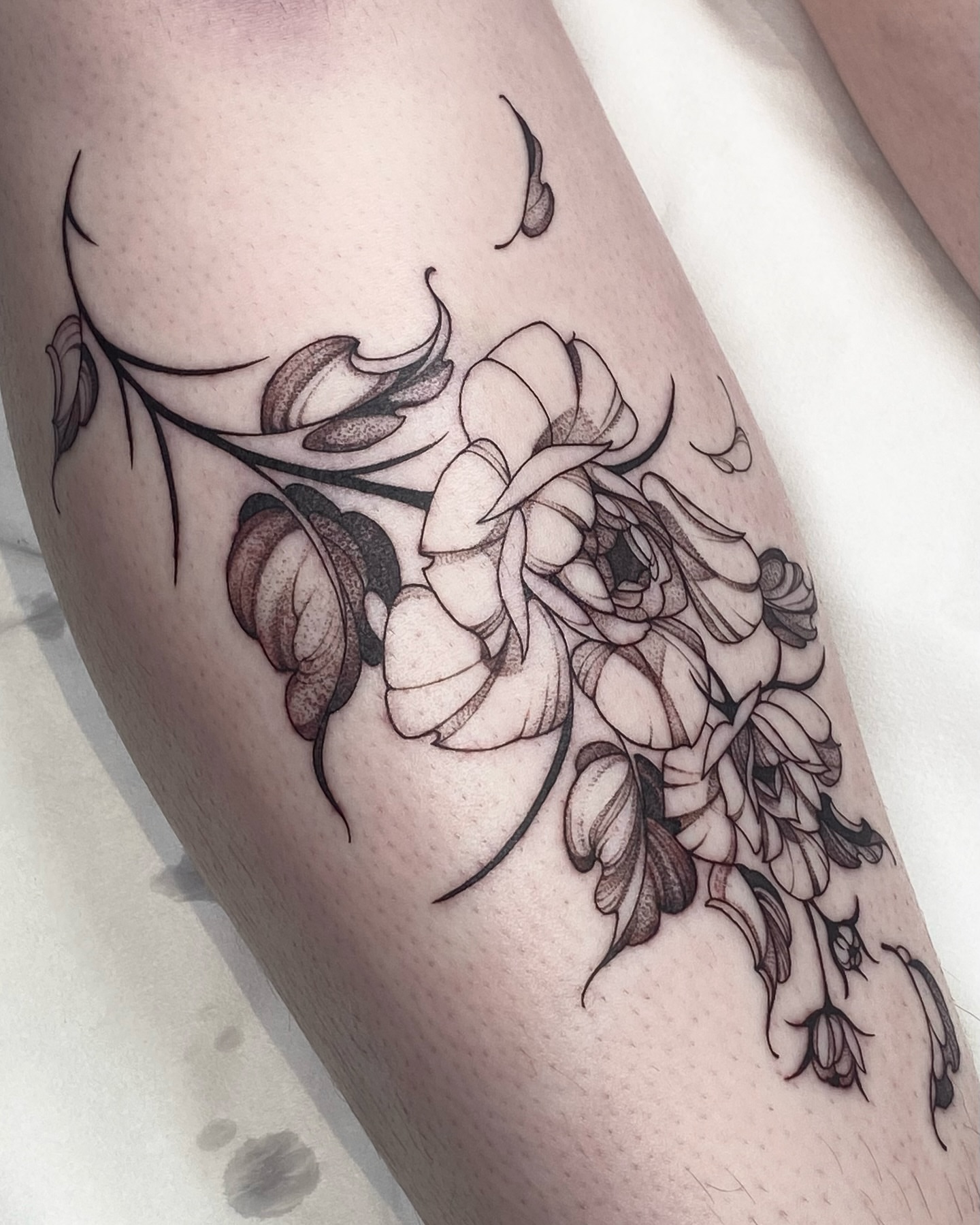 Floral arrangement black and grey tattoo on the thigh by IVY