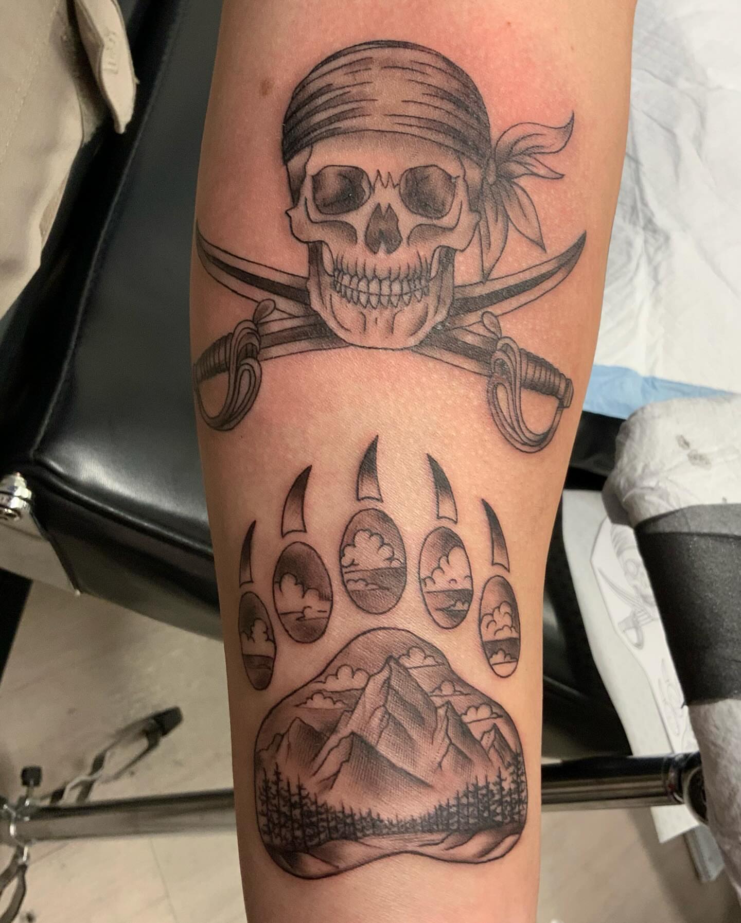 Pirate skull and sabers realism tattoo on the forearm by QUEEN TATTOO Stephanie Larson