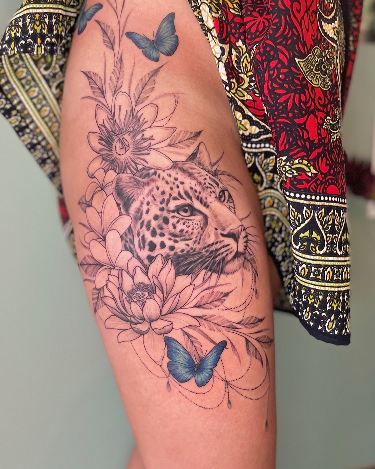 Leopard and flowers realism tattoo on the thigh by Lo Boverod - La Passoire  - Tatoueuse -