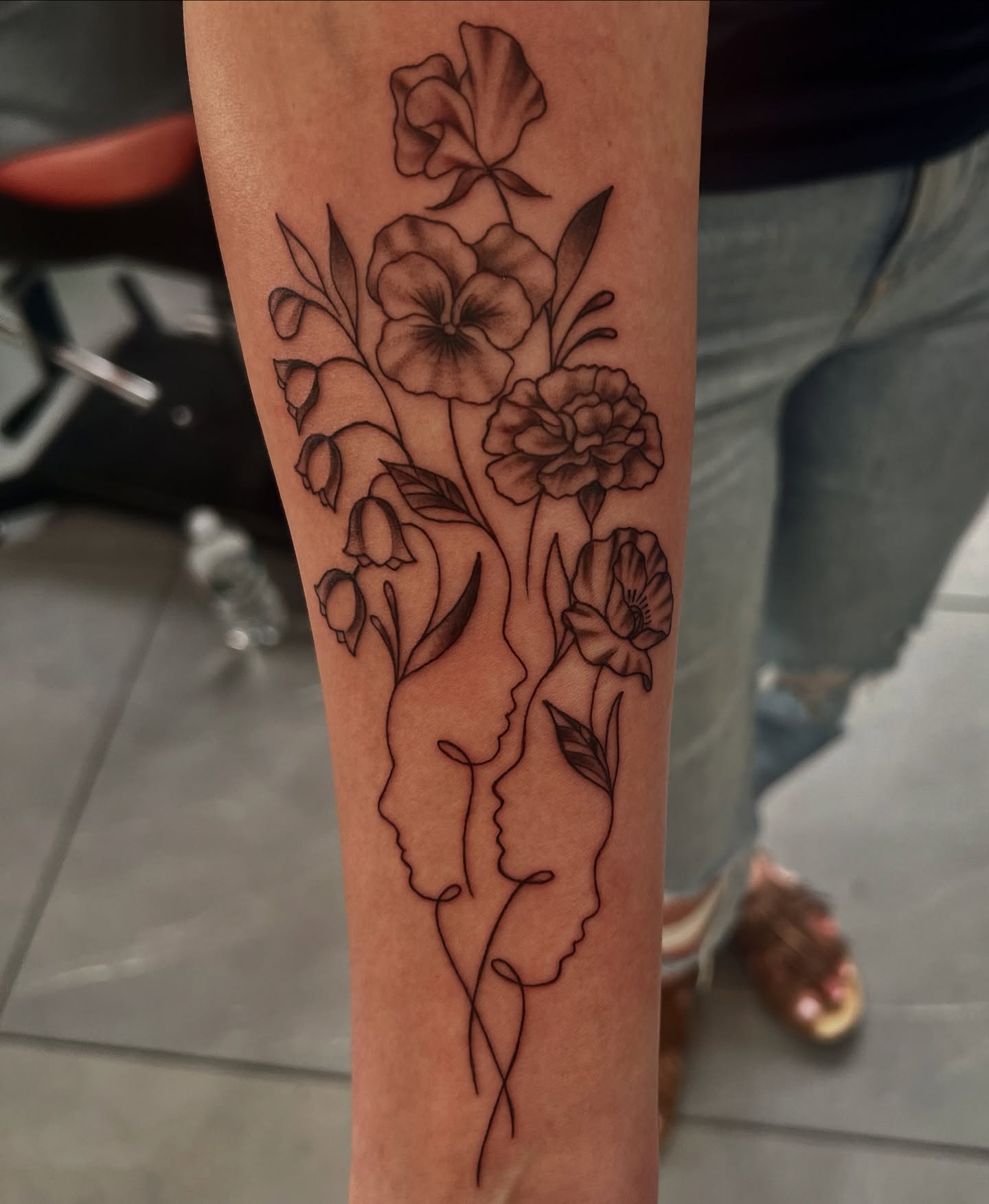Floral bouquet black and grey tattoo on the forearm by Nikki Malfitano