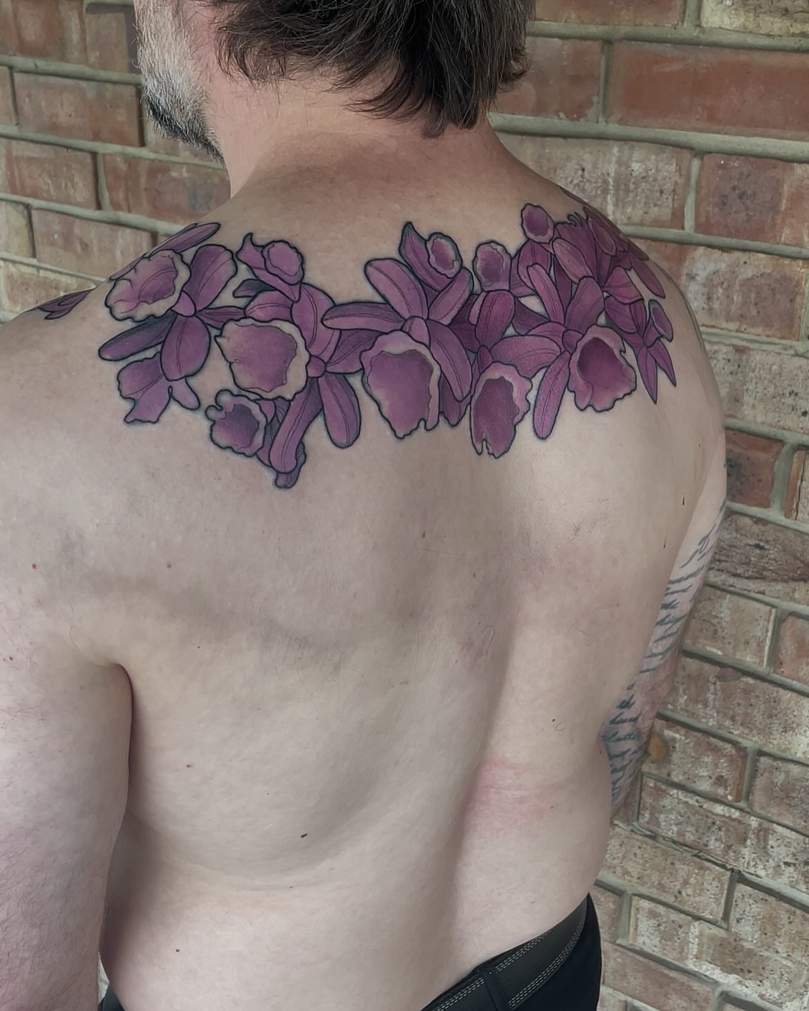 Orchids realism tattoo on the back by Nathan Evans