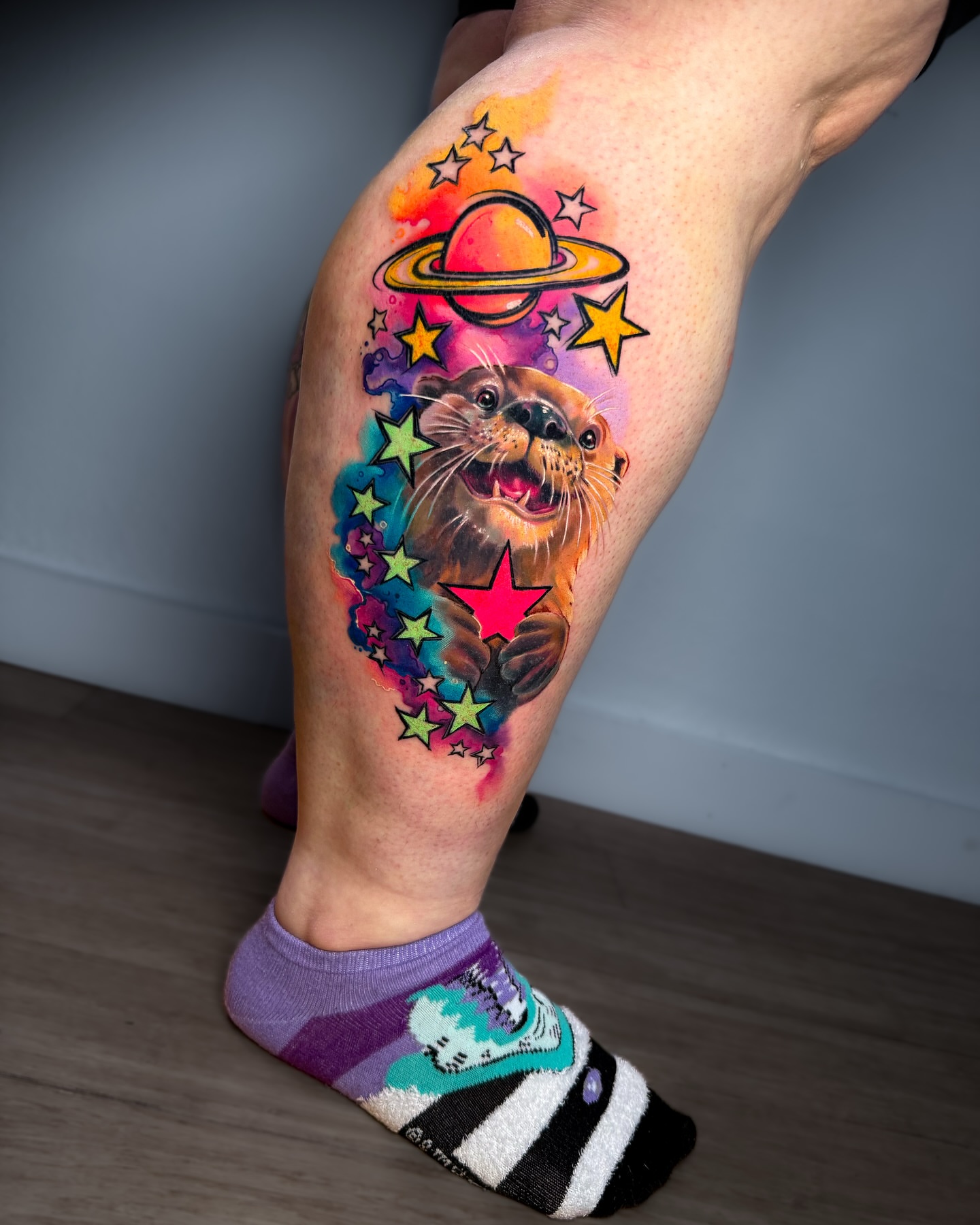 Otter watercolor tattoo on the leg by Amy Zager