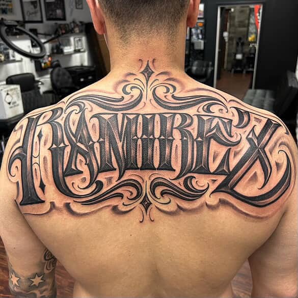 Ramirez lettering script tattoo on the back by $krypt
