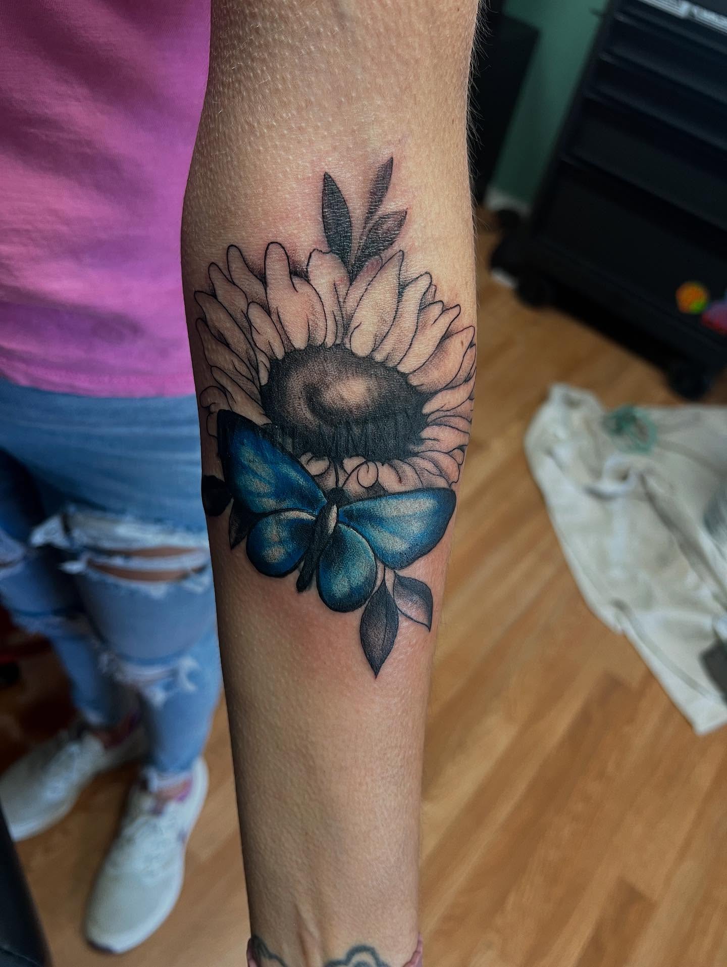 Sunflower and butterfly realism tattoo on the forearm by Katie Sayre