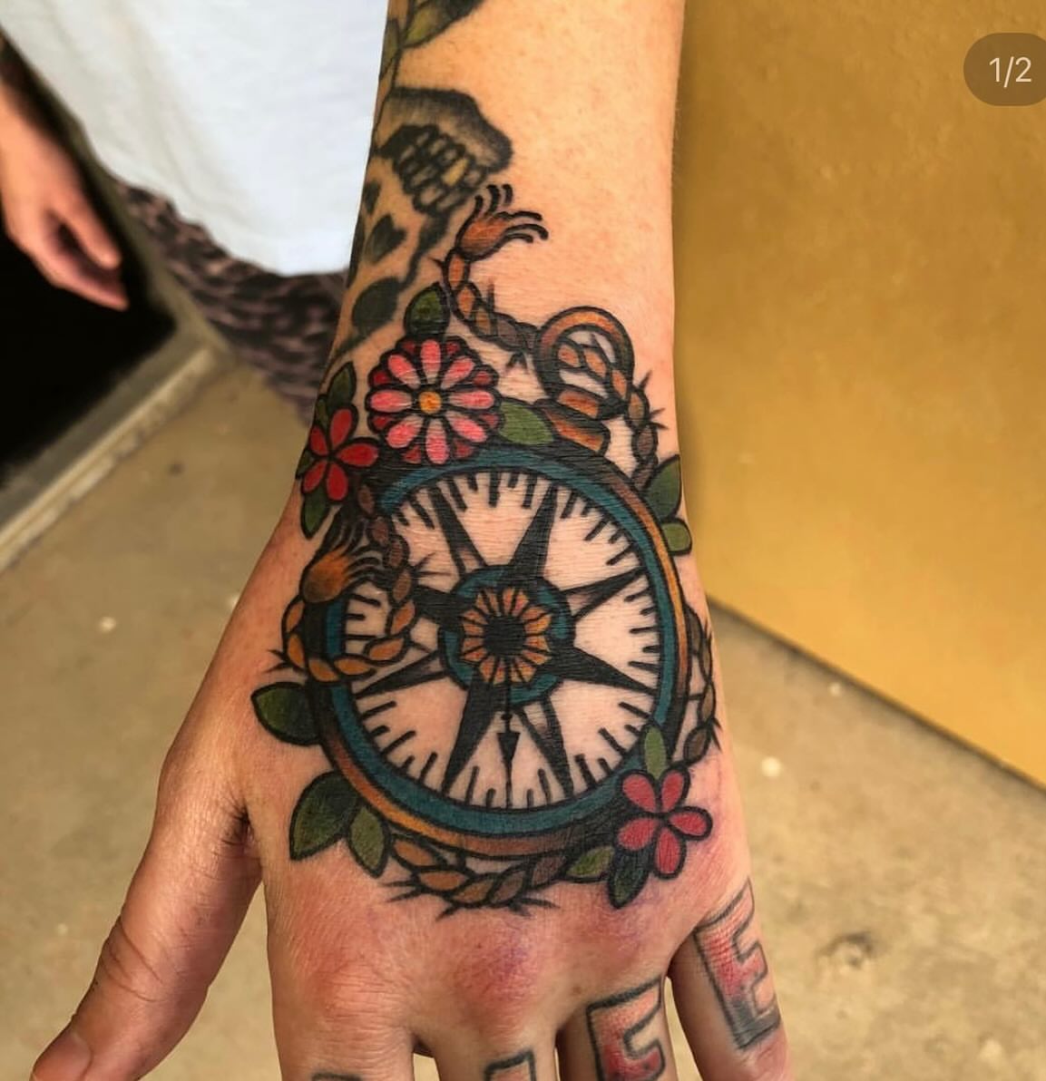 Compass with floral wreath American traditional tattoo on the hand by Shayna Soderstrom, Columbus, Ohio