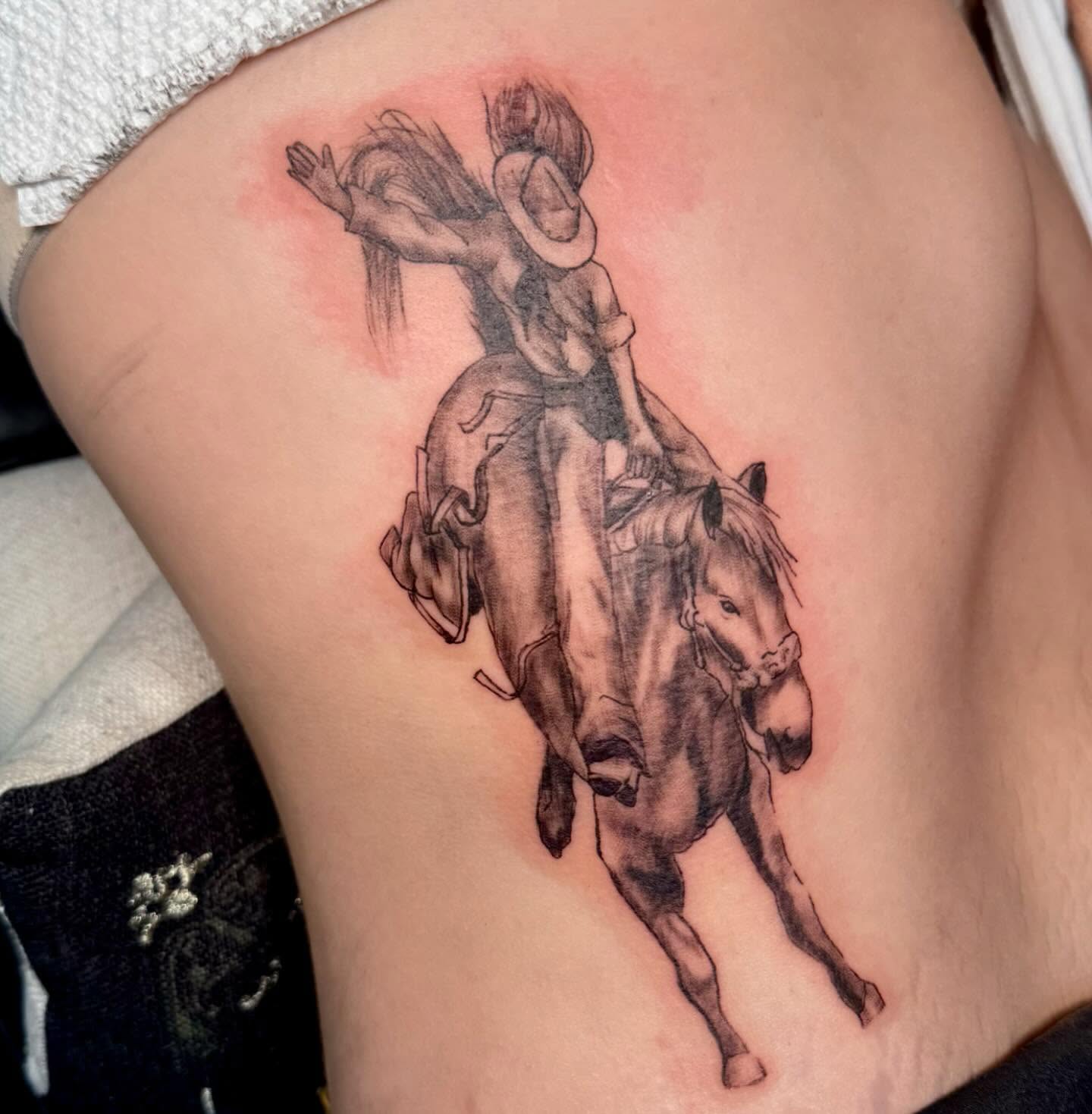 Cowboy riding horse black and grey tattoo on the thigh by Nina Rush