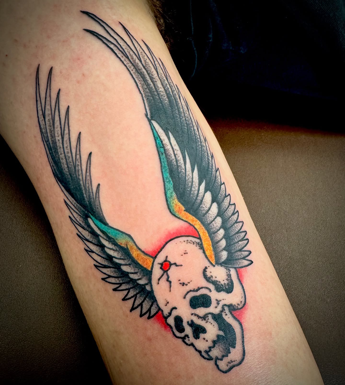 Wings and skull American traditional tattoo on the forearm by Kristen