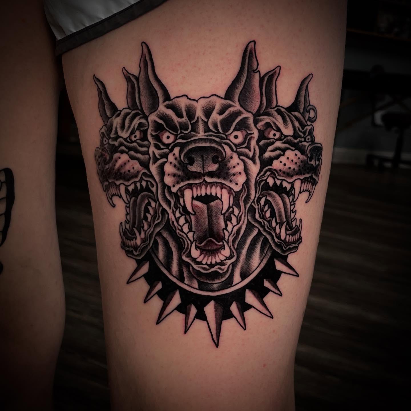 Demon head black and grey tattoo on the thigh by Caleb Baker