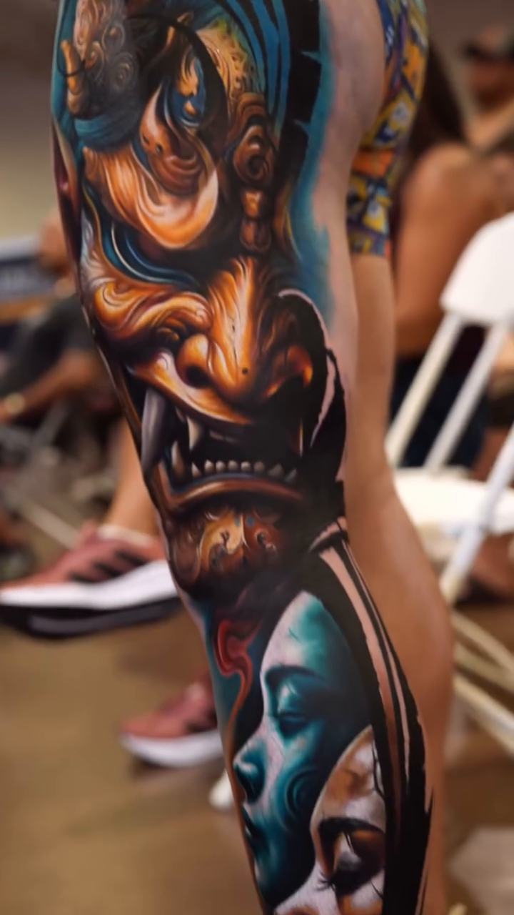 Hannya mask and faces surrealism tattoo on the upper arm by Guillermo Columbie, Houston, Texas