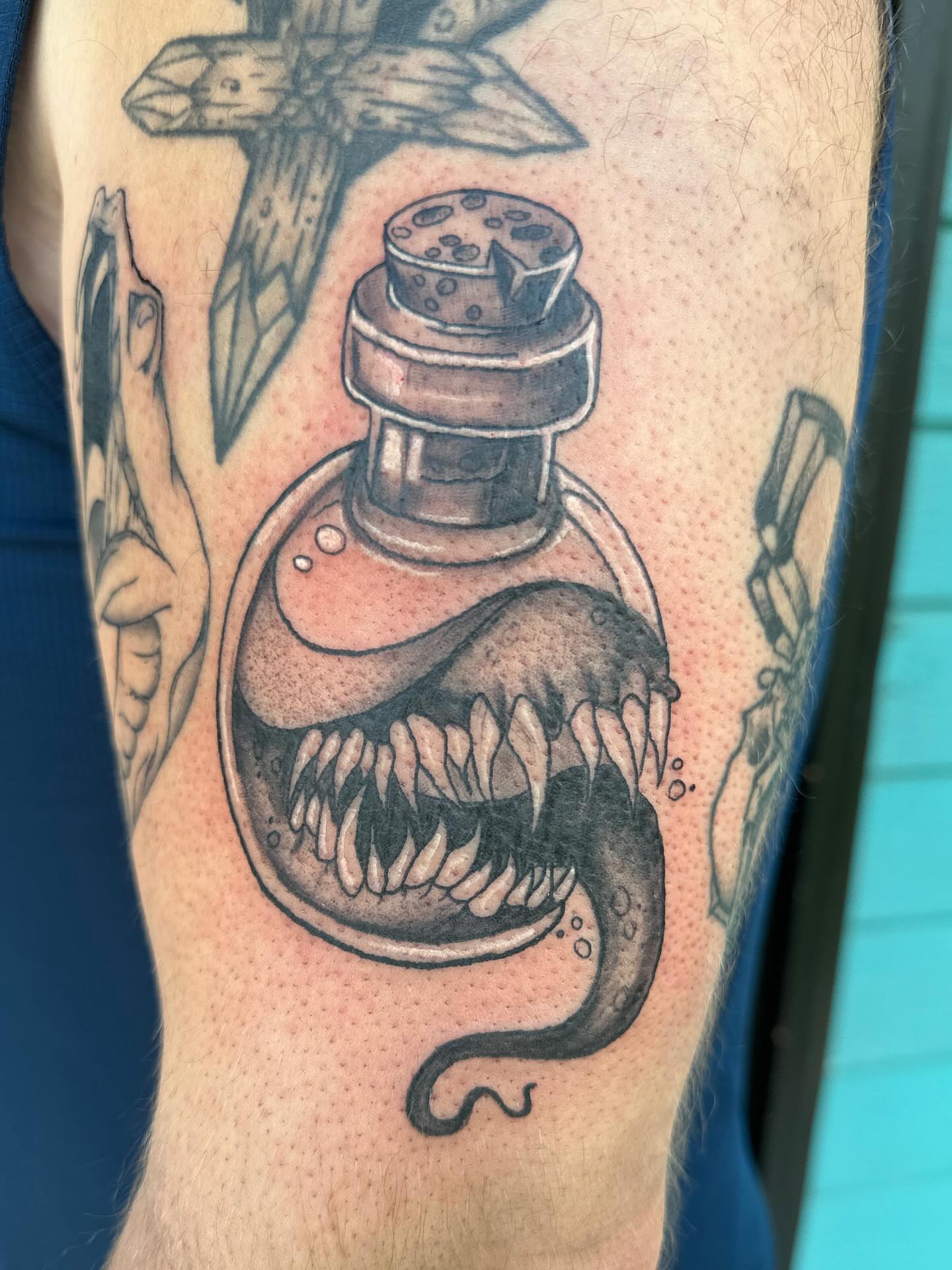 Snake in bottle realism tattoo on the forearm by Mika'la Berry