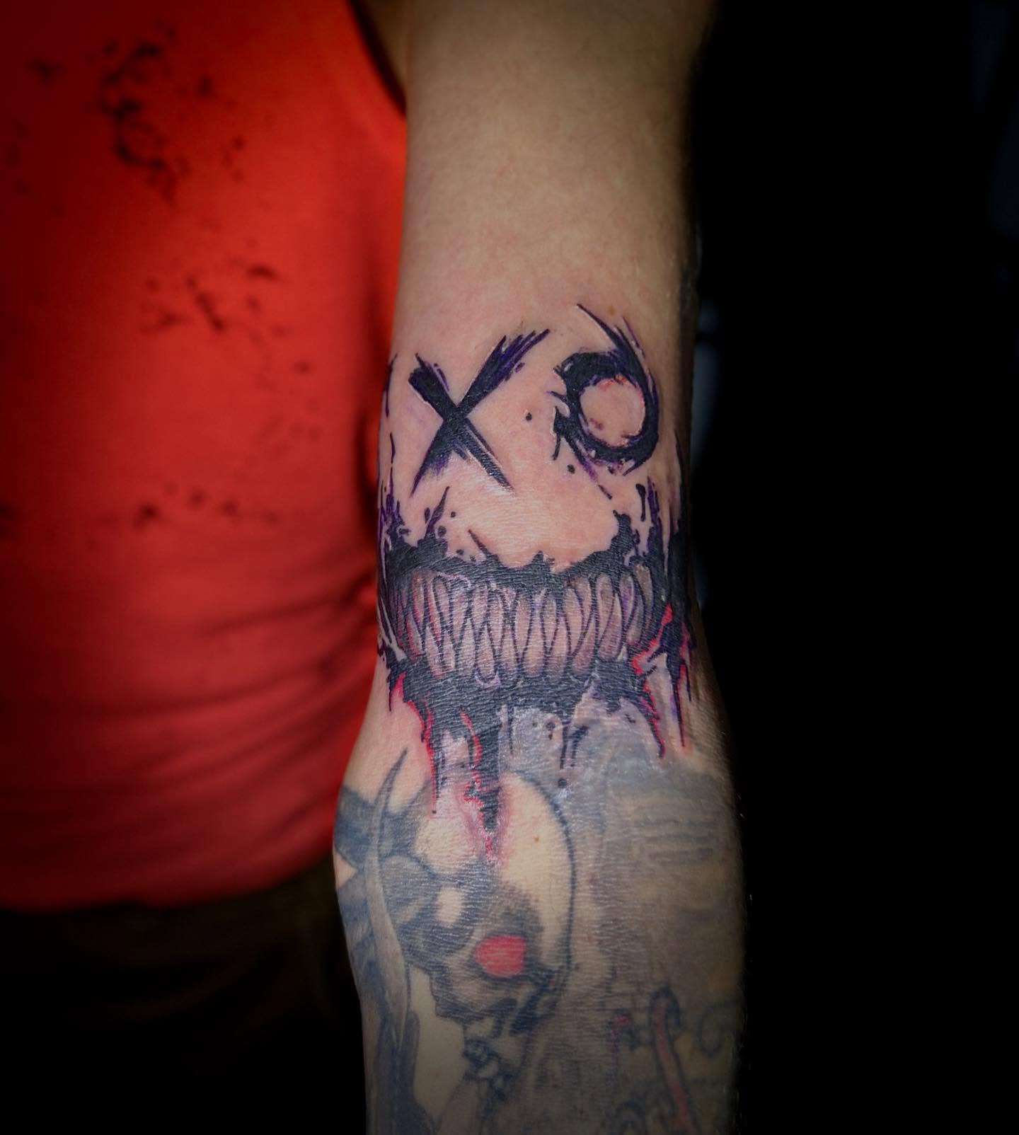 XO with mouth black and grey tattoo on the forearm by ɢɢ sᴛʏʟᴇs