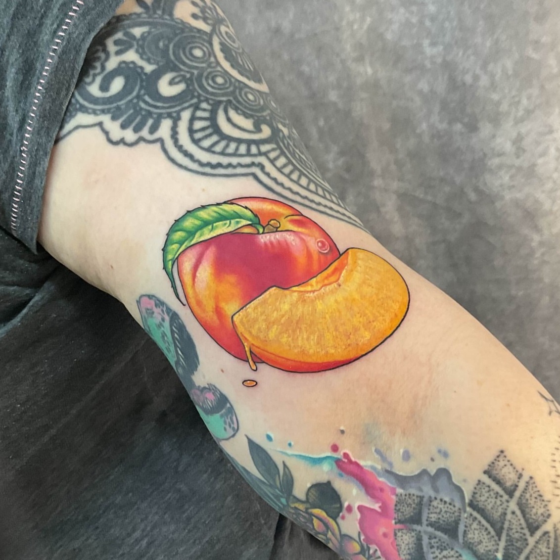 Peach realism tattoo on the forearm by Iram Withencroft