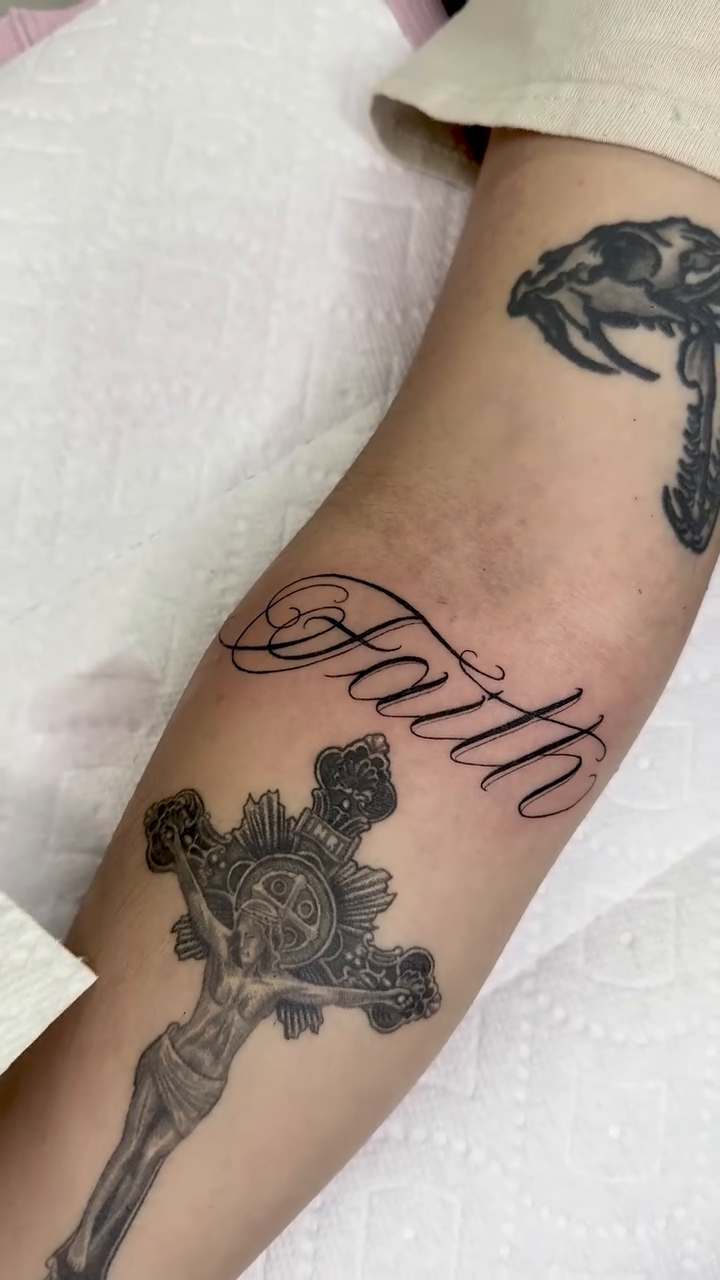 Crucifix and the word Faith realism tattoo by Tattoo Artist