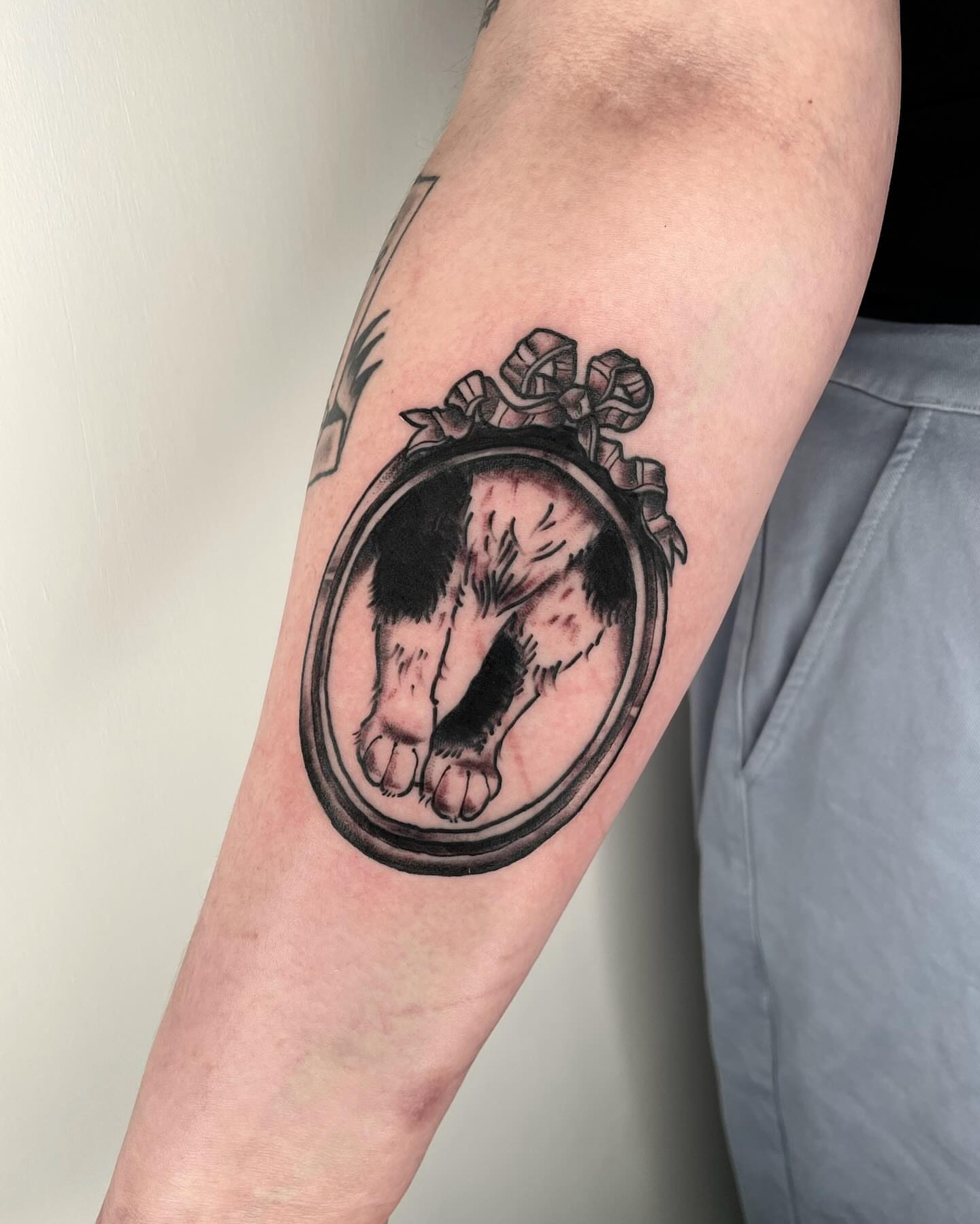 Dog paw in mirror black and grey tattoo on the forearm by G. Clover ⚧︎, Chicago, Illinois