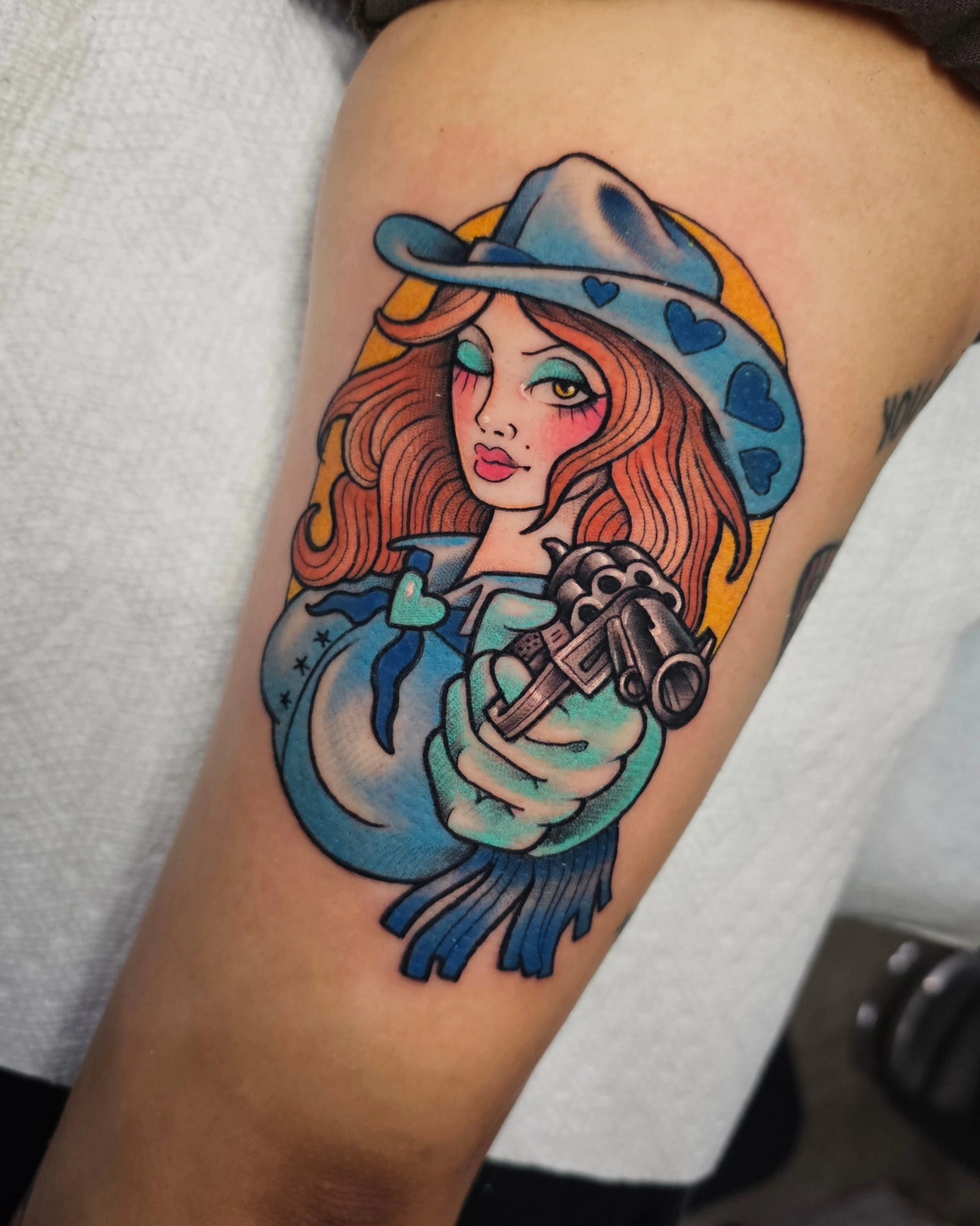 Cowgirl with revolver American traditional tattoo on the thigh by Shannon
