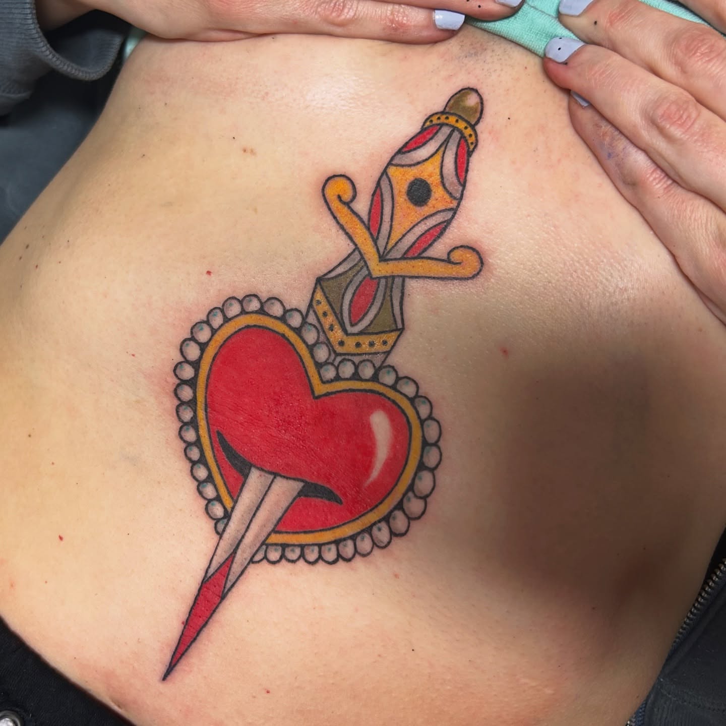Heart with dagger American traditional tattoo on the back by Lauren Caldwell 🔮🌙