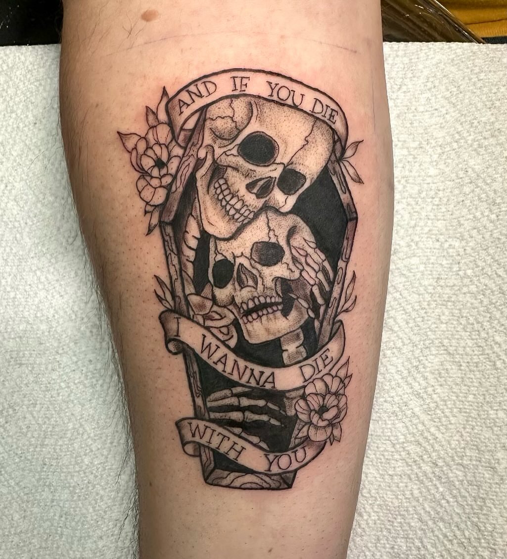Skulls and banners black and grey tattoo on the calf by Mika'la Berry