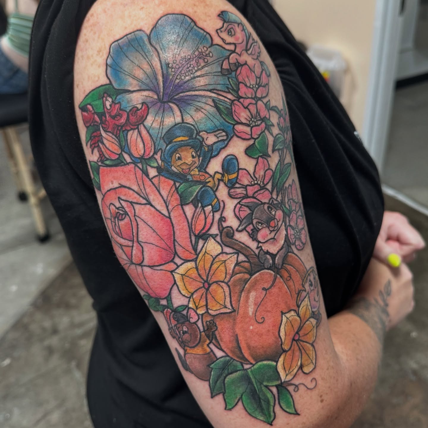 Pinocchio and flowers new school tattoo on the upper arm by Emily K Lingg
