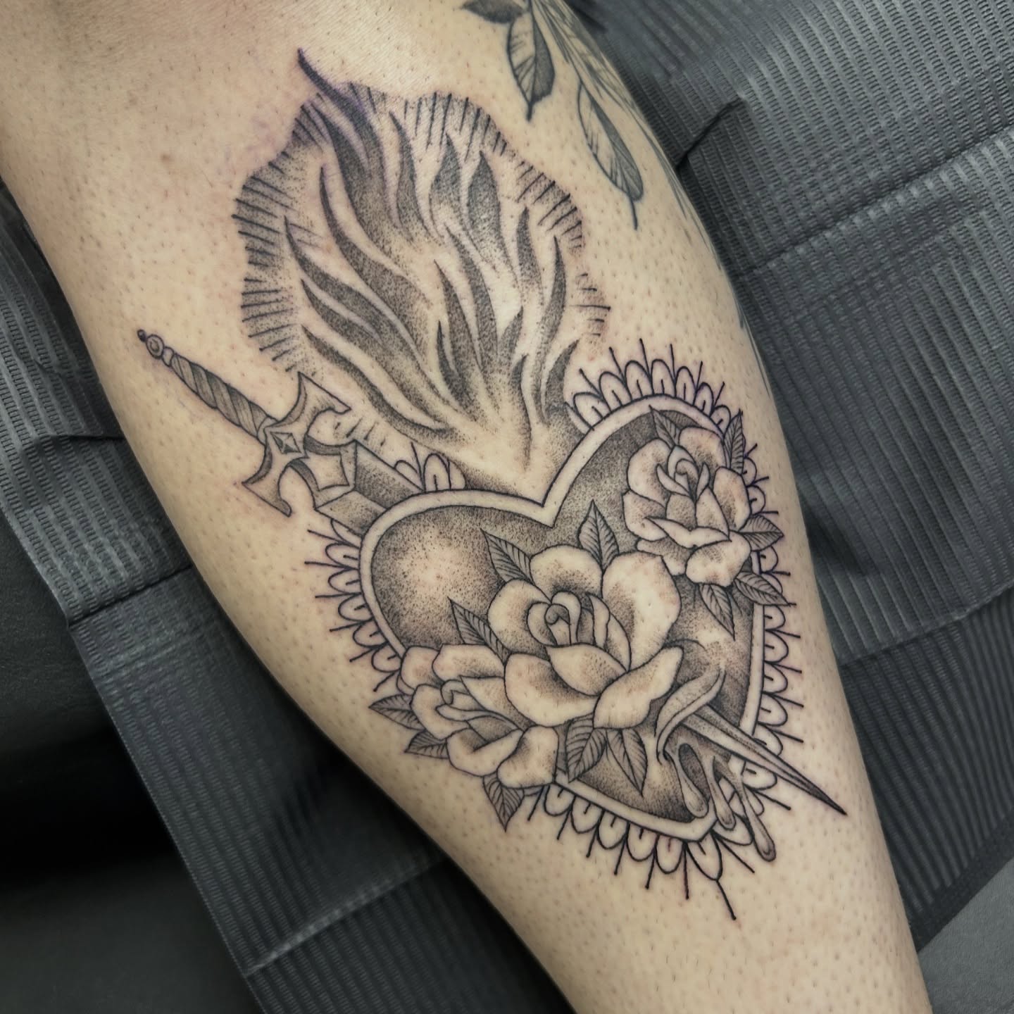 Heart with roses and sword dotwork tattoo on the thigh by Patricia Cunningham