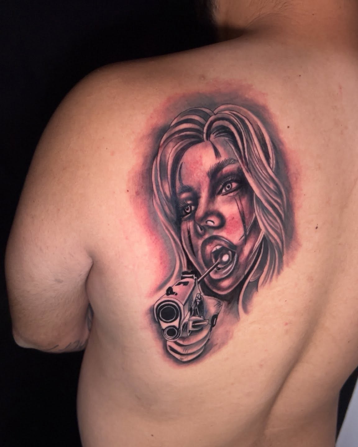 Woman with gun realism tattoo on the shoulder by Bryant Ramirez