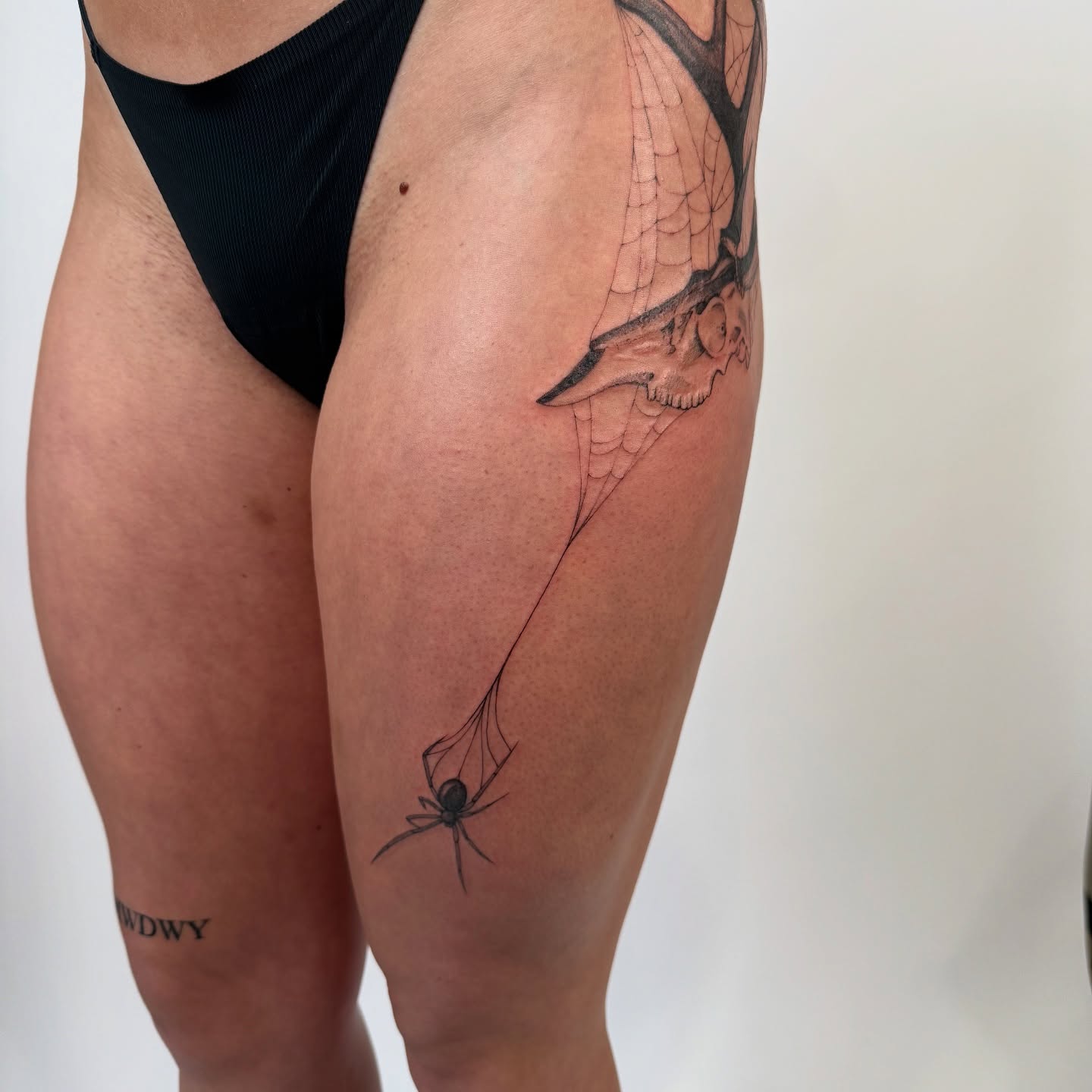 Spider web black and grey tattoo on the thigh by bre