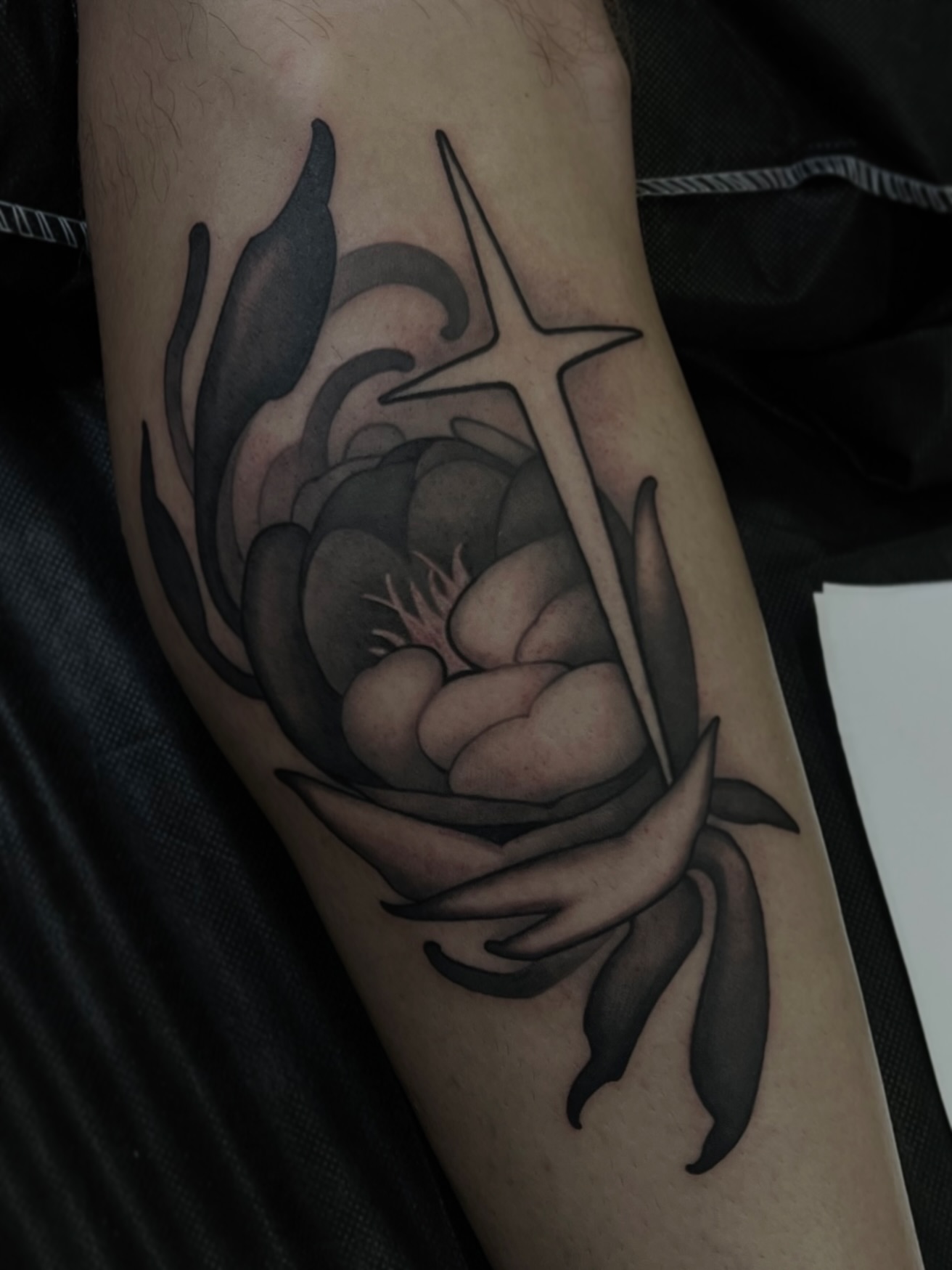Peony and cross black and grey tattoo on the forearm by Madison Ast Tattoo