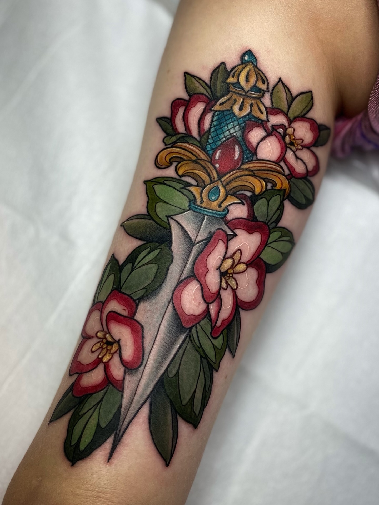 Sword and flowers American traditional tattoo on the forearm by Tayler Pearson, Fort Collins, Colorado