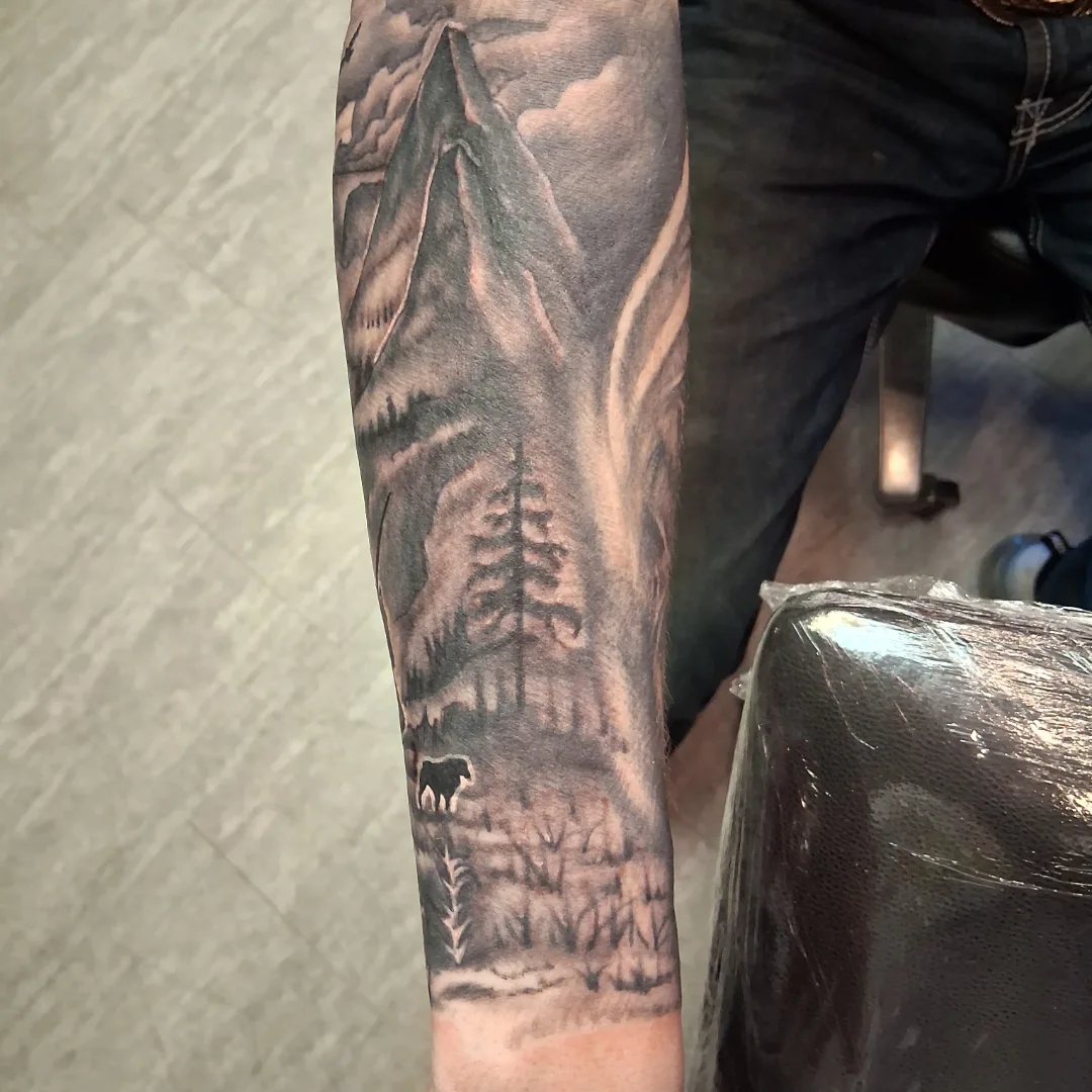 Mountain landscape realism tattoo on the forearm by Dave Johnson, Billings, Montana