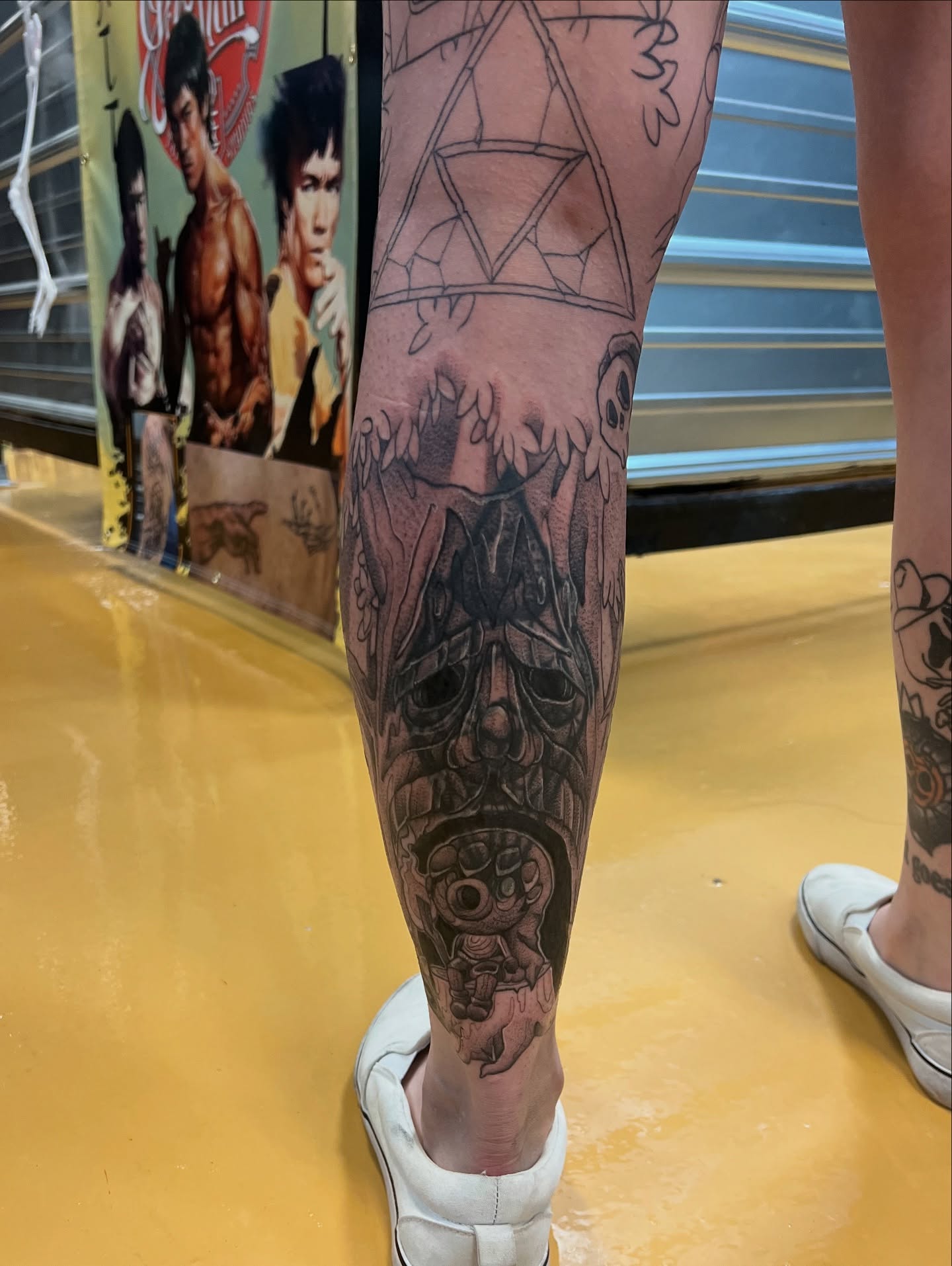 Mask black and grey tattoo on the calf by Kat