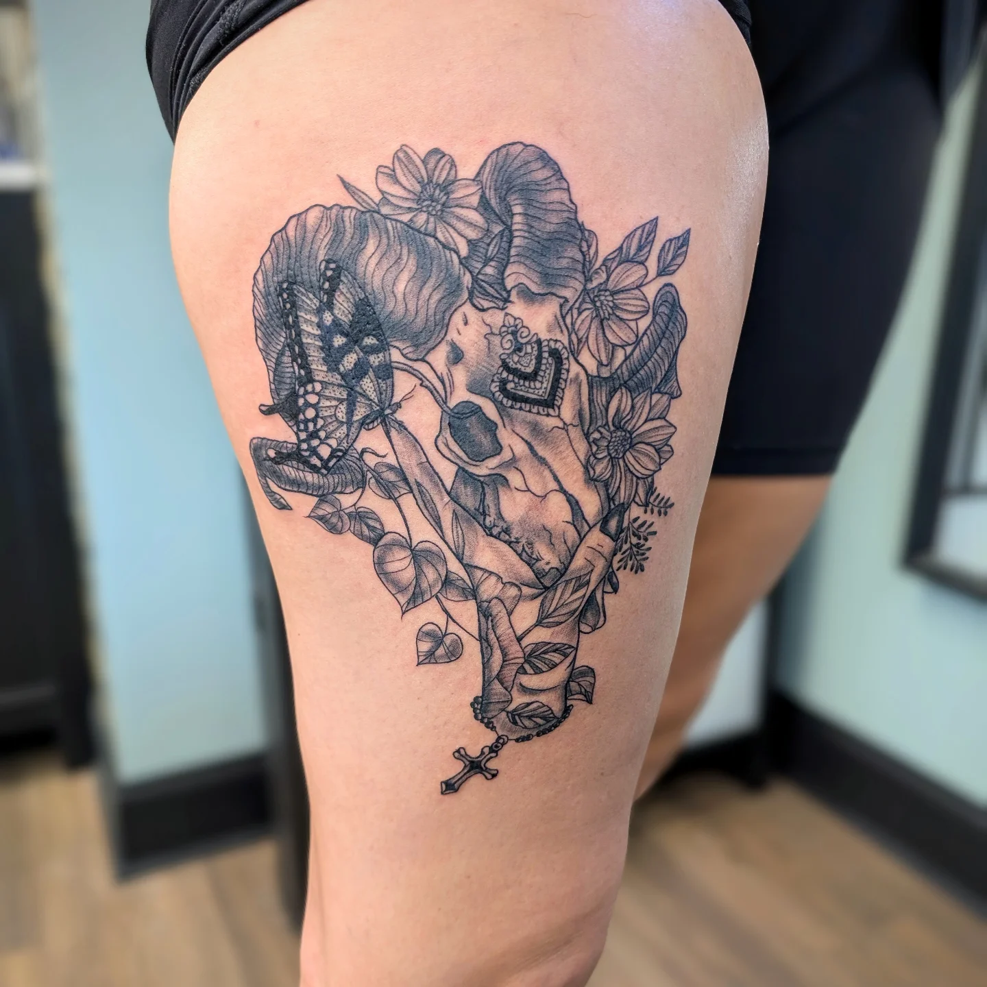 Skull and flowers ornamental tattoo on the thigh by Devon Ward, Portland, Oregon