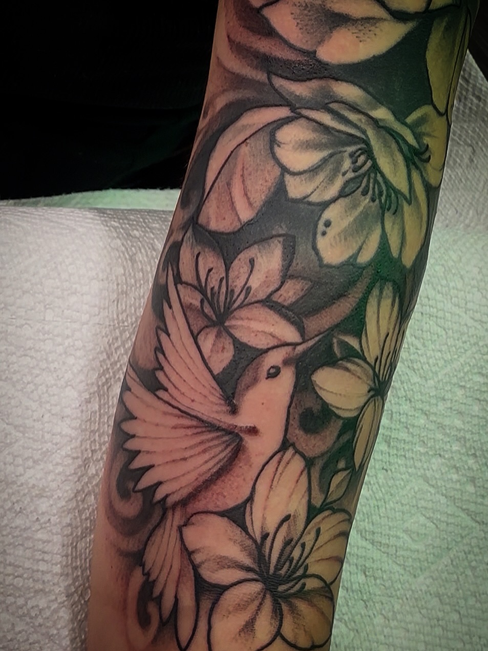 Bird and flowers new school tattoo on the forearm by Ogden Tattoo Parlor