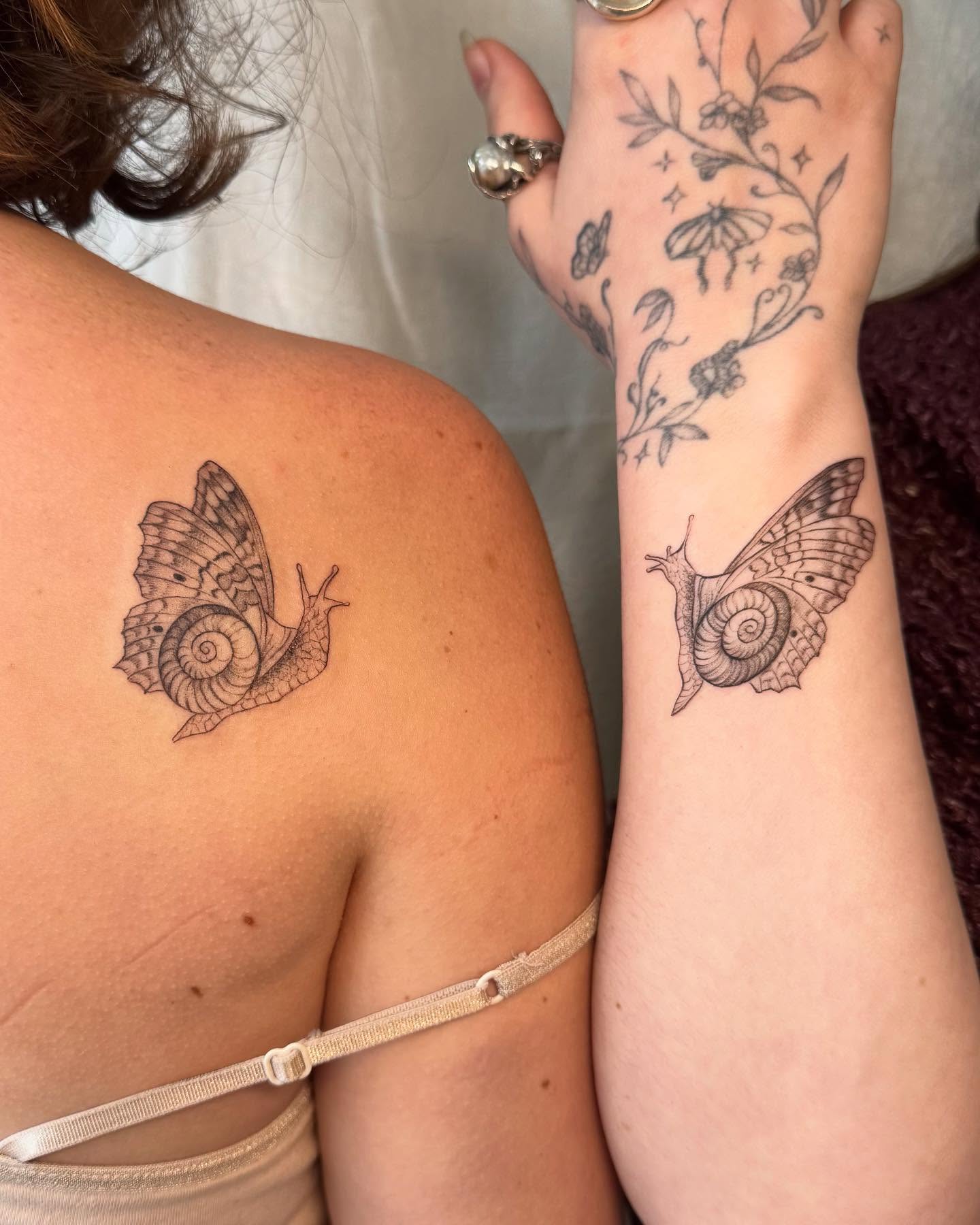 Snail black and grey tattoo on the upper arm by RyAnn Lynn