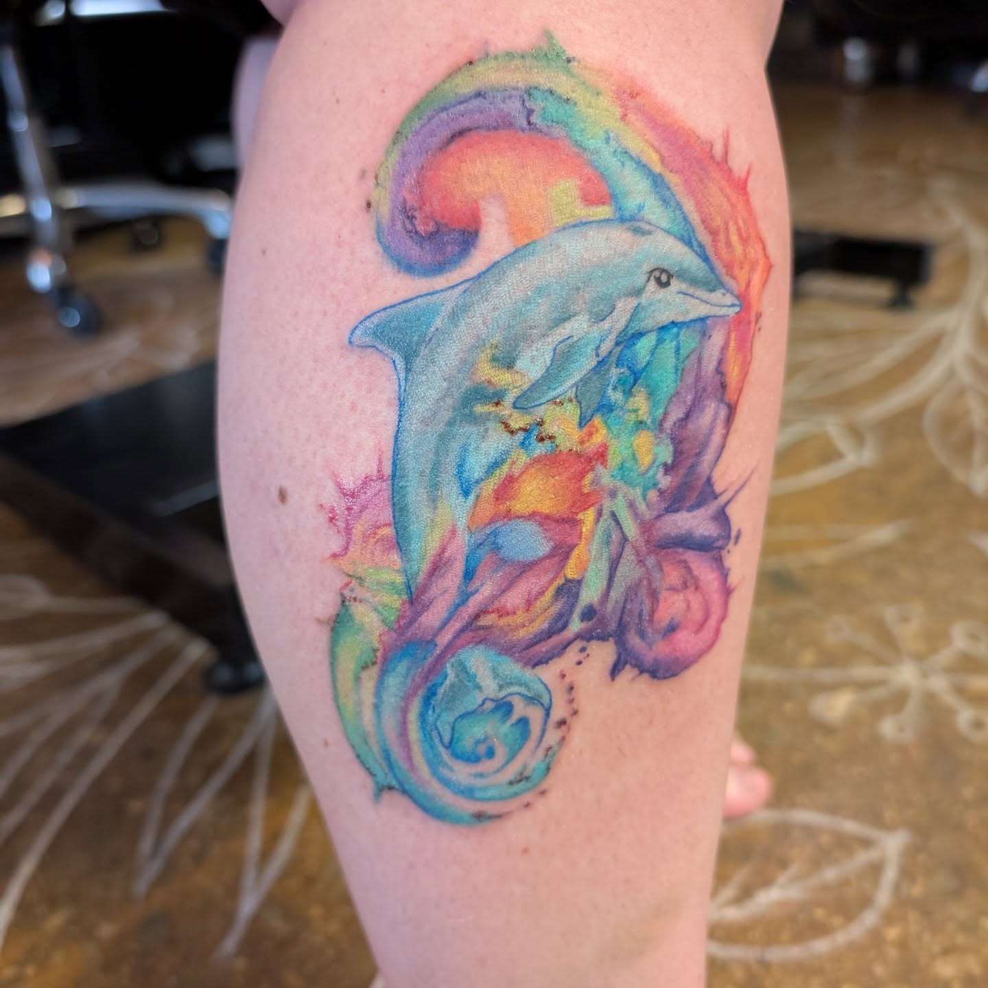 Dolphin watercolor tattoo on the leg by Cat