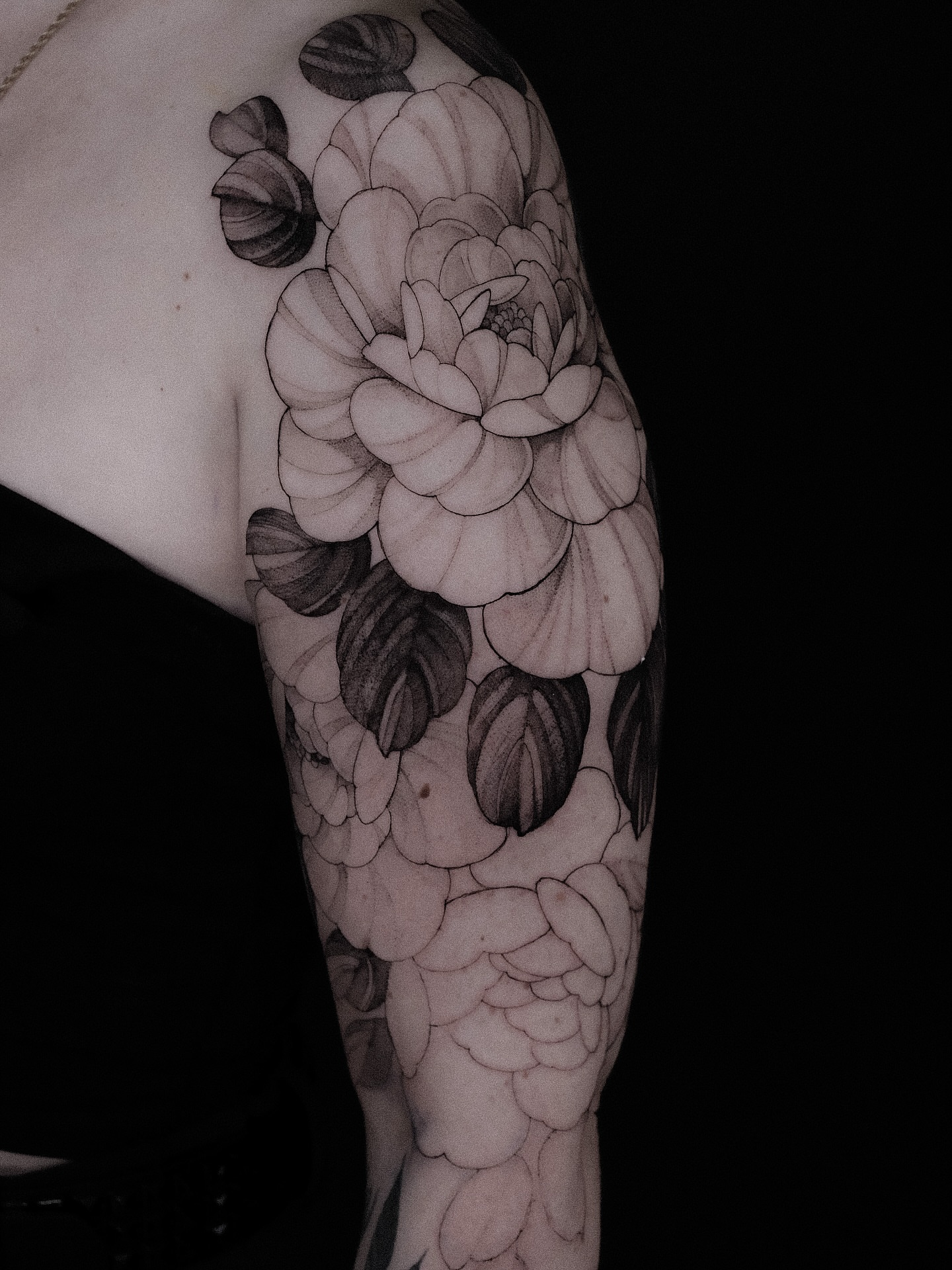 Floral arrangement black and grey tattoo on the upper arm by Alena Zozulenko