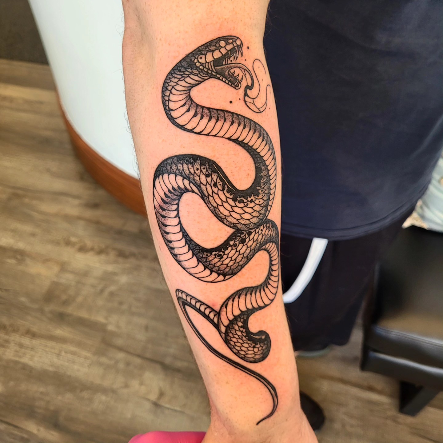 Snake black and grey tattoo on the forearm by Wray Saulsberry