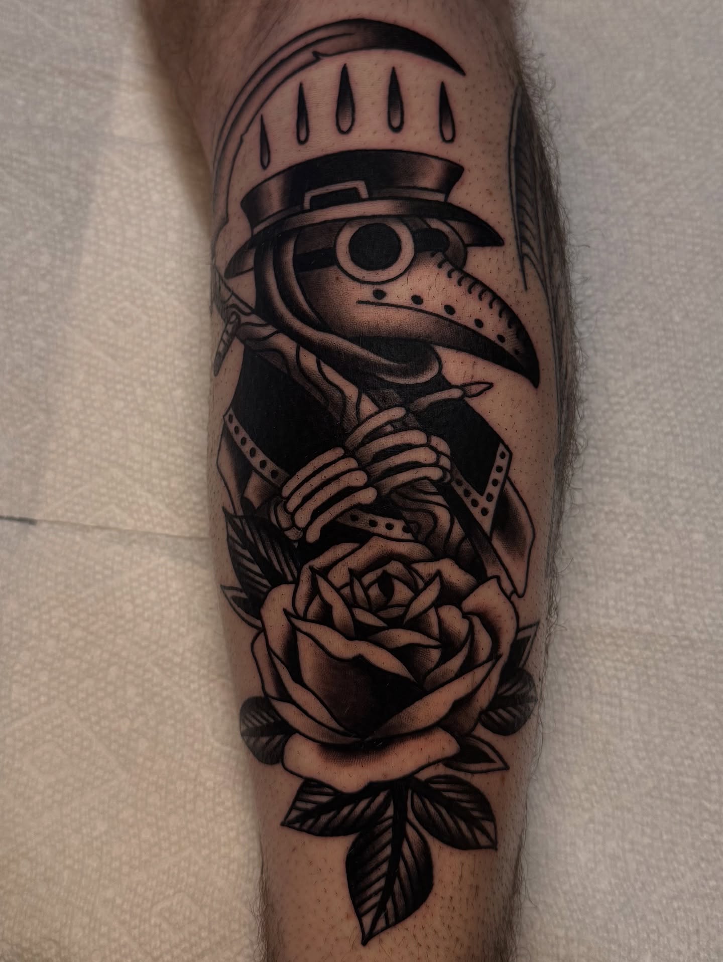 Plague doctor with rose black and grey tattoo on the forearm by Cory Allen