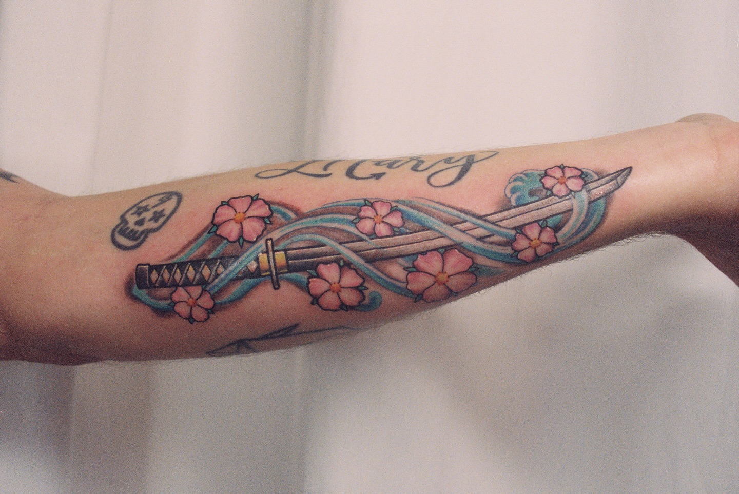 Katana and cherry blossoms japanese irezumi tattoo on the forearm by Joseph Jeffers