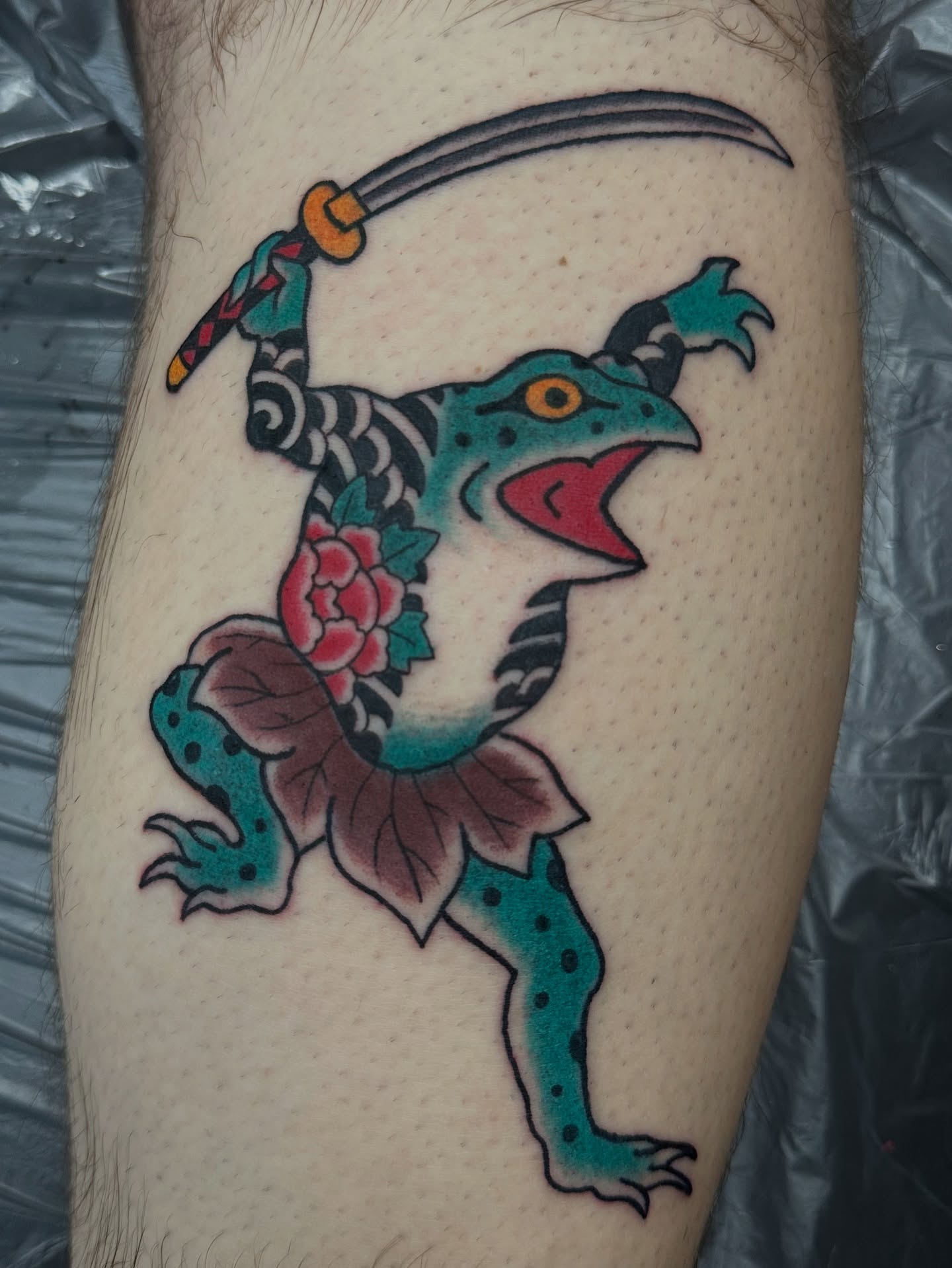 Lizard with sword American traditional tattoo on the forearm by Daniel Skillingstead
