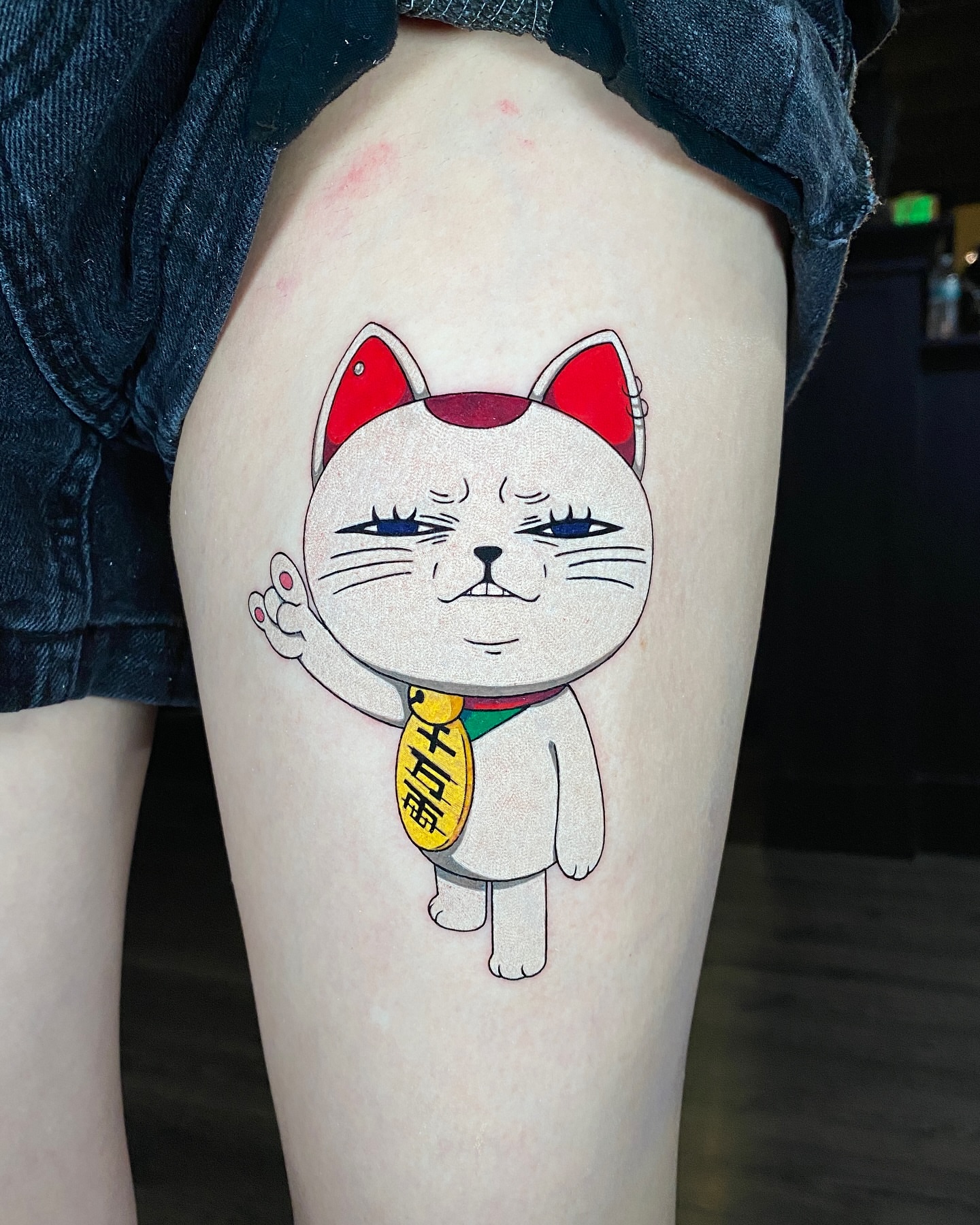 Maneki-neko illustrative tattoo on the thigh by Gerardo Brawder
