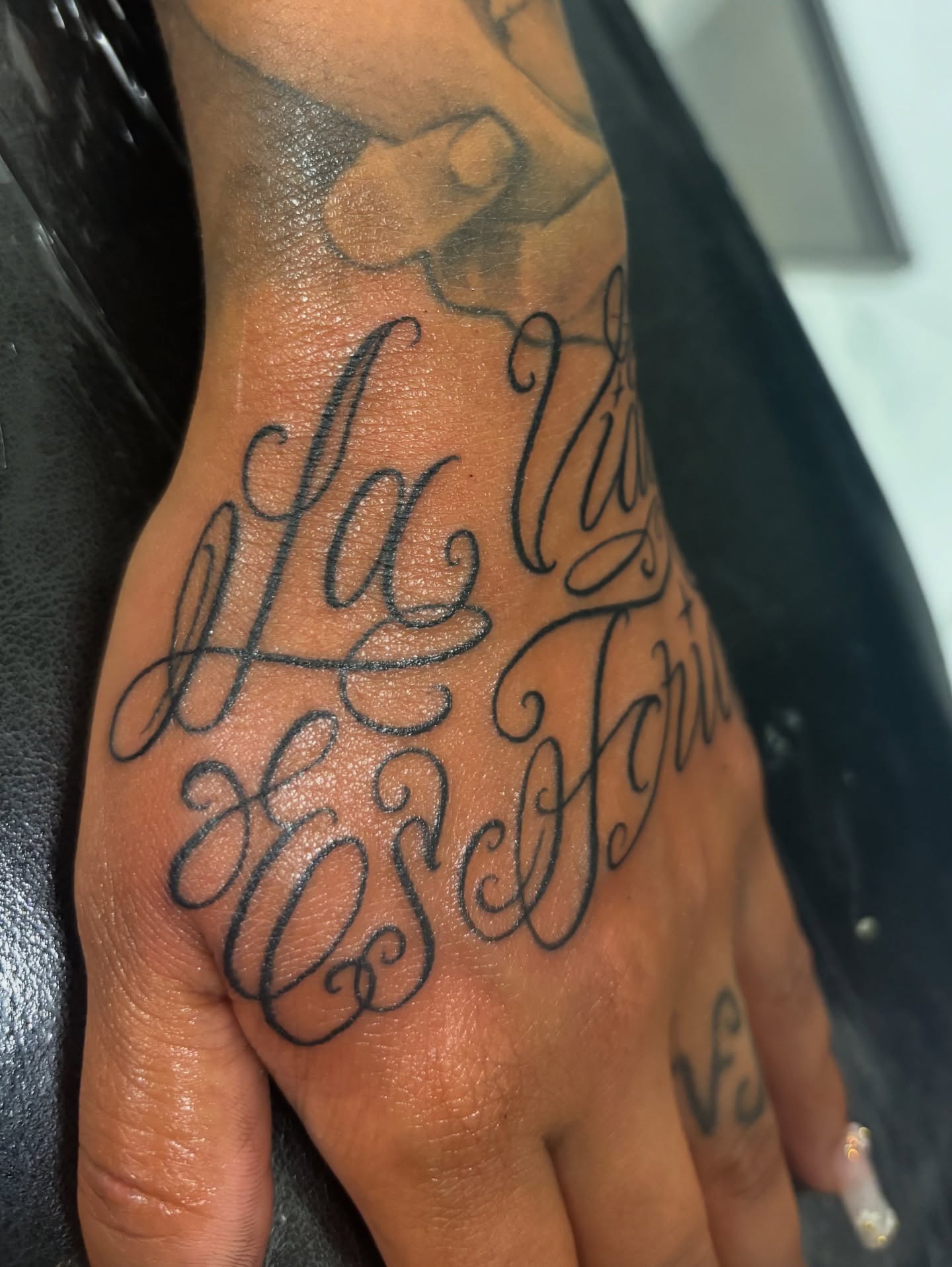 La Vida Es Joven lettering script tattoo on the hand by Cristiano Ochoa, Elk Grove, California