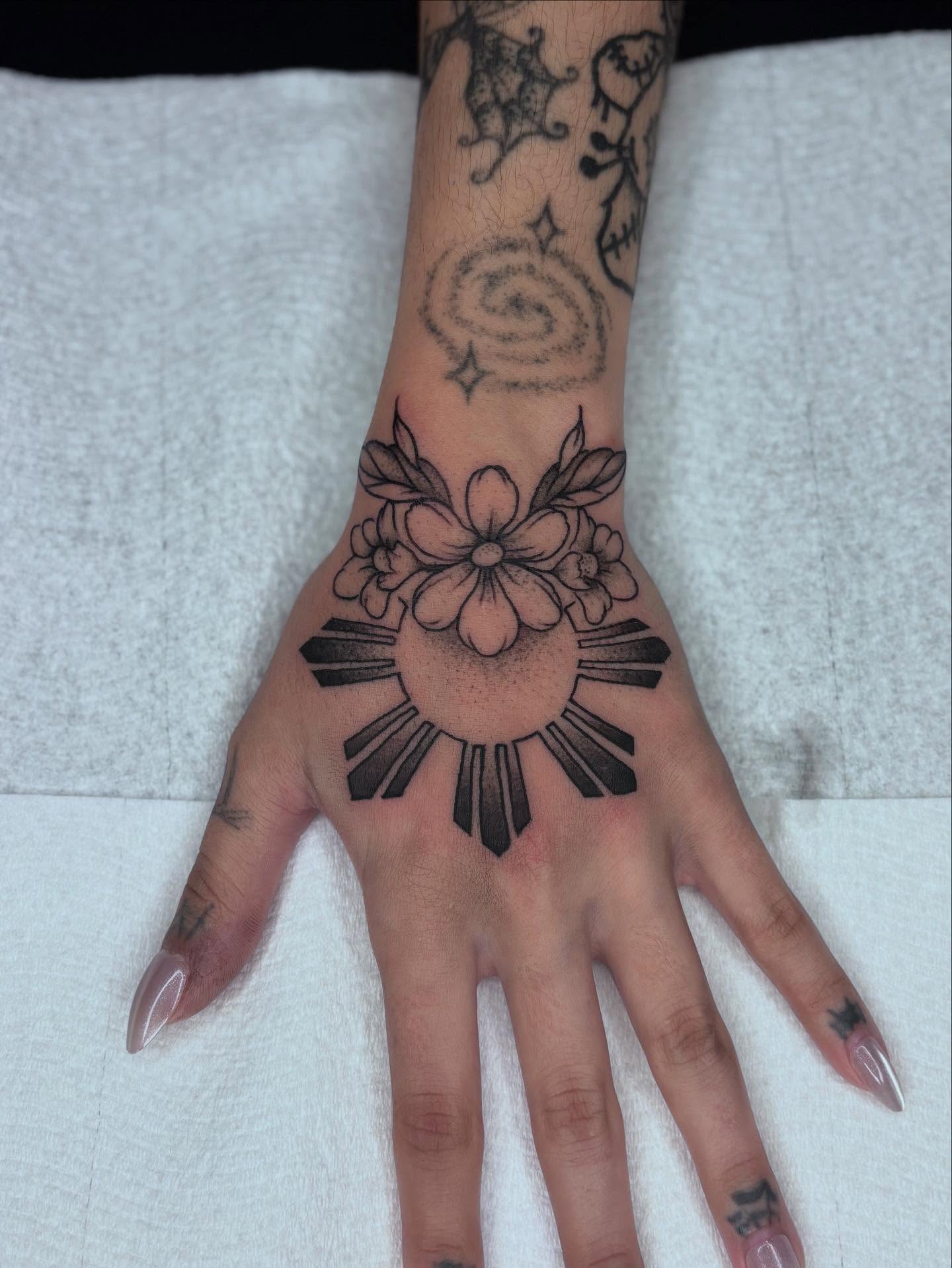 Sun and flowers black and grey tattoo on the hand by π»πΈπ½π½, Ypsilanti, Michigan