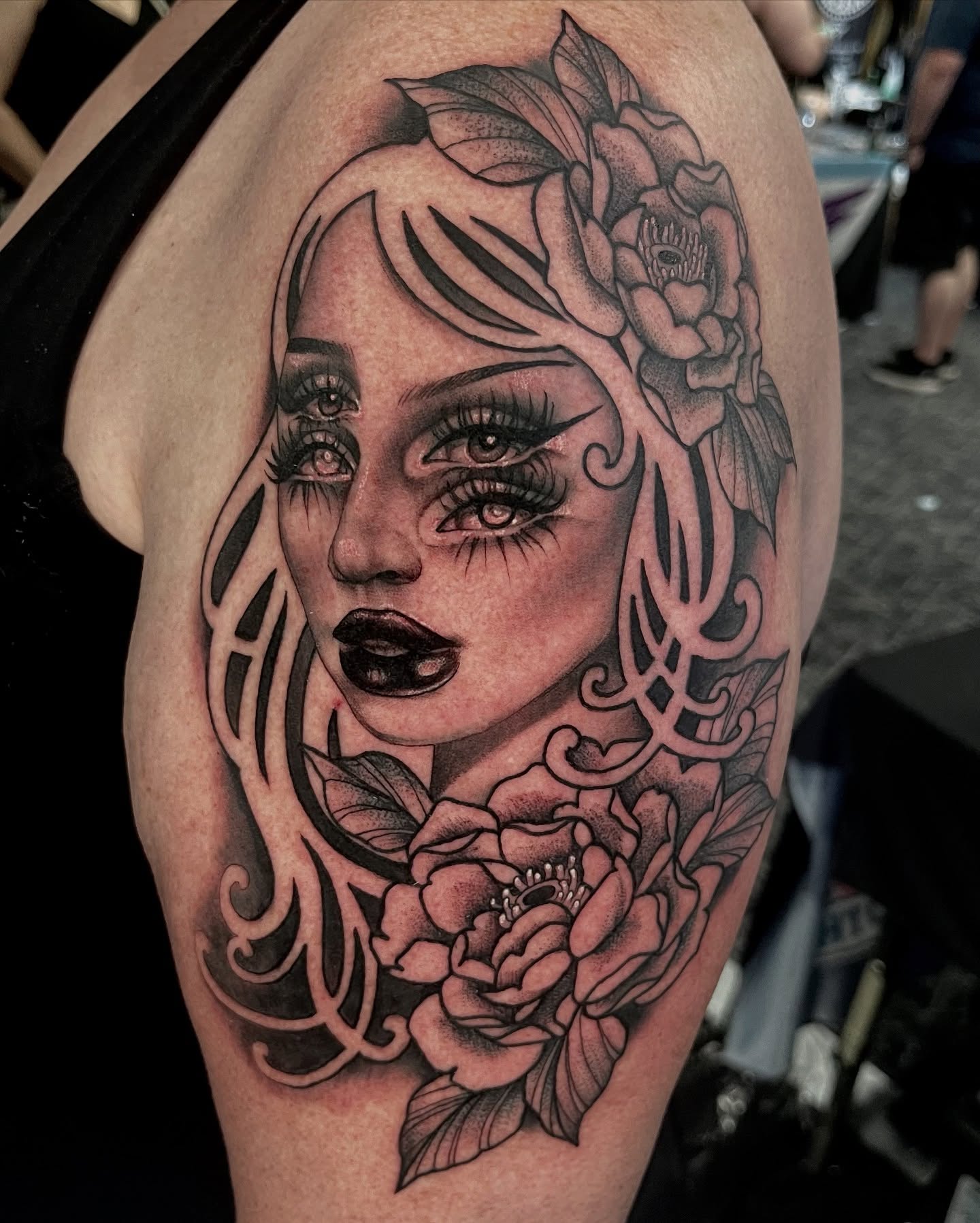 Woman with flowers realism tattoo on the shoulder by Holli Marie