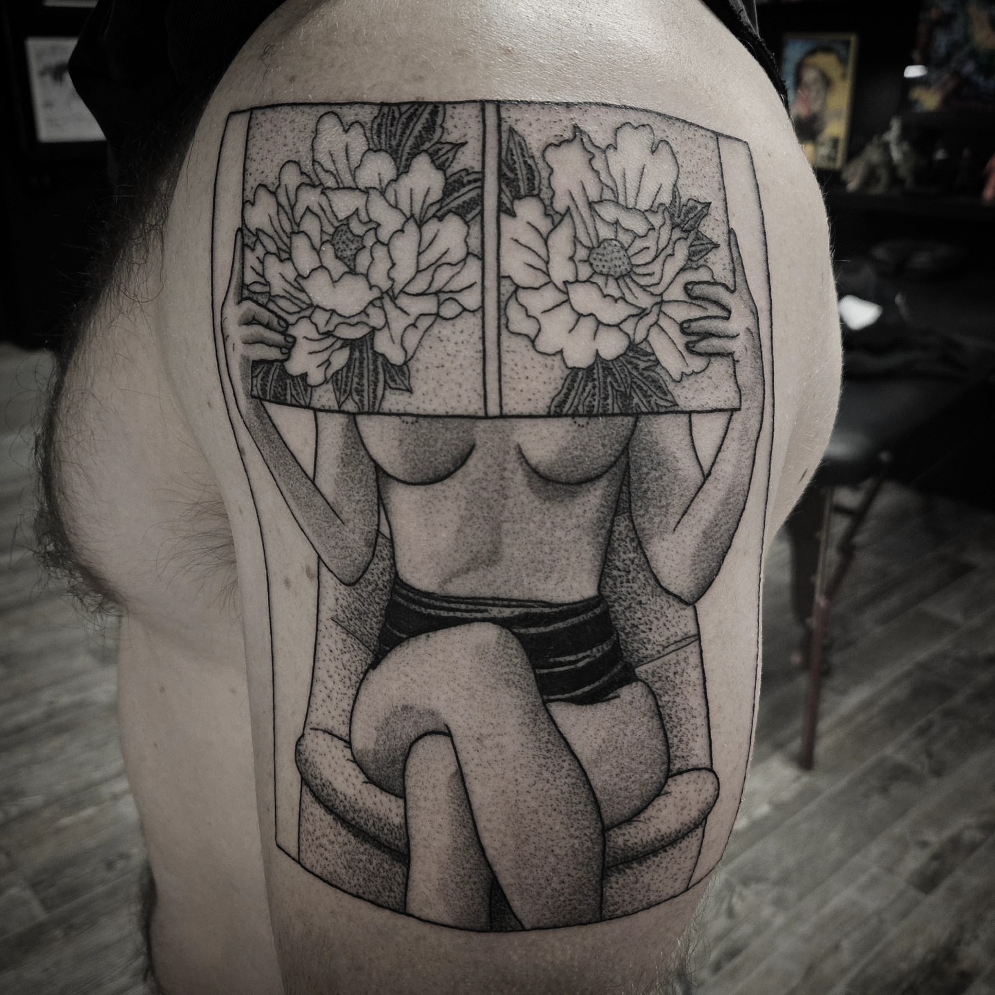 Nude figure with flowers dotwork tattoo on the shoulder by Kirk George