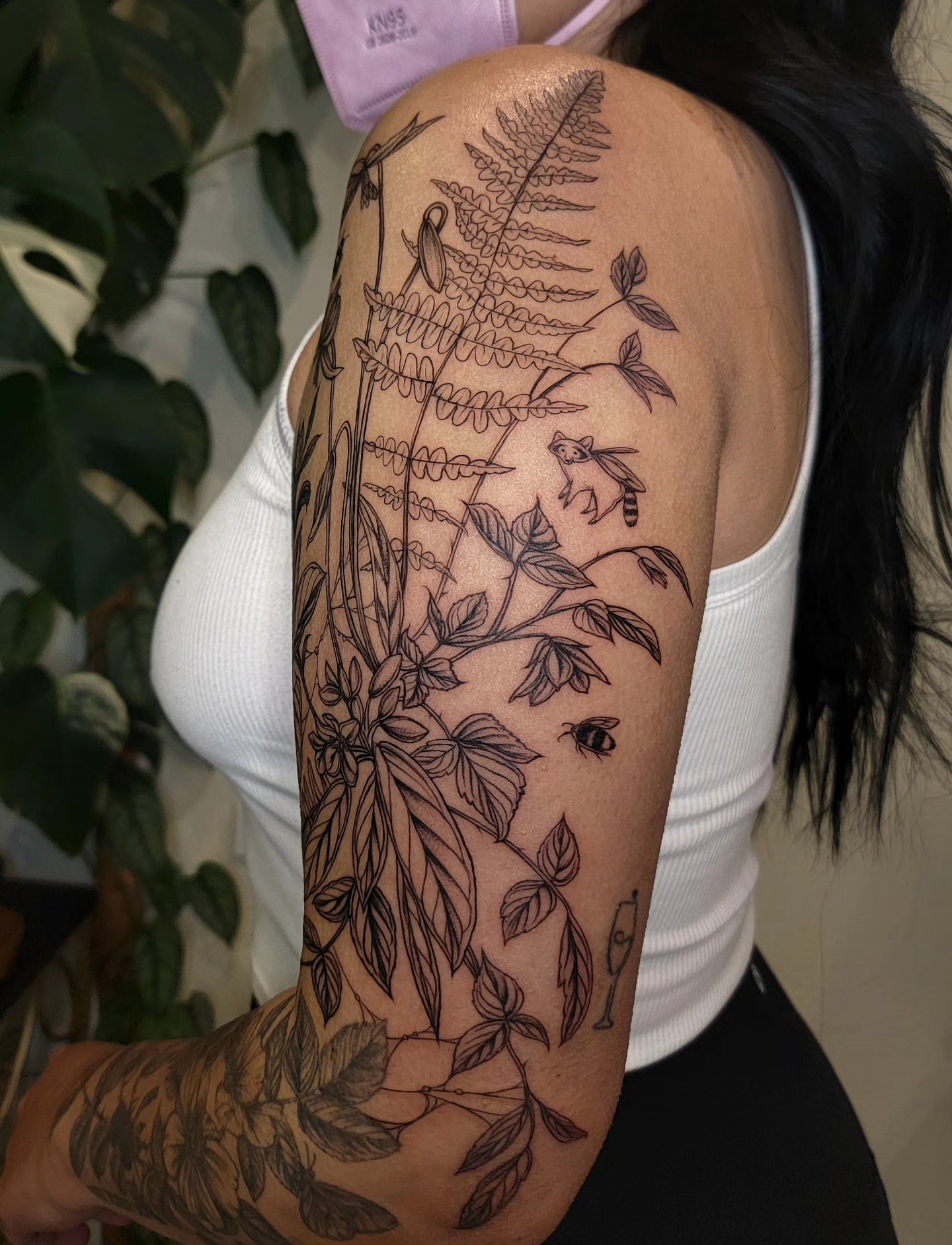Fern and bees black and grey tattoo on the upper arm by Sierra (cc) Klein